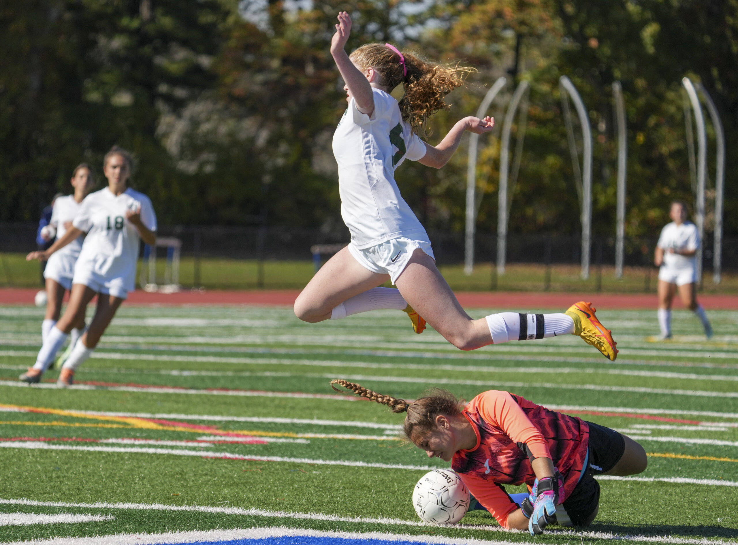 Hurricane Sarah Gormley leaps over Hauppauge goalie goalie Taylor Mileti as she comes off her line to intercept the ball.    RON ESPOSITO