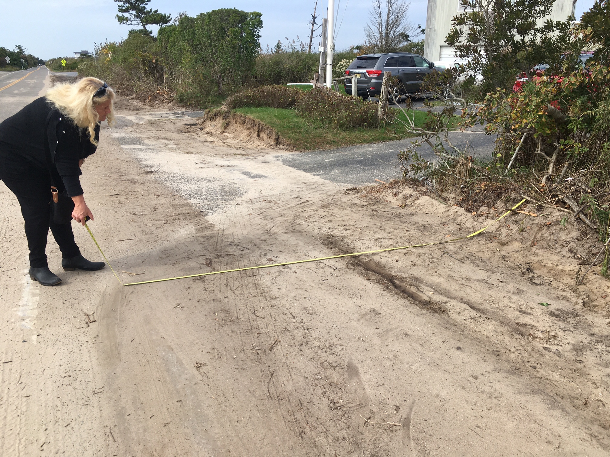 Lynda Packard measures from the chopped landscaping to the road.    KITTY MERRILL