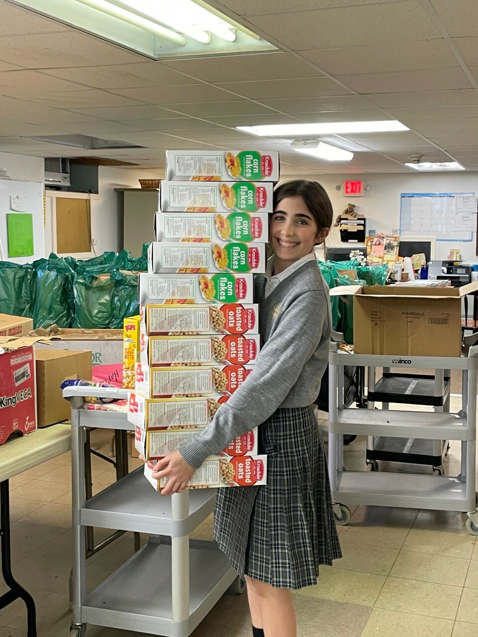 Our Lady of the Hamptons School Prep 8 student Emma Tillotson volunteers at Heart of the Hamptons food pantry stocking shelves as part of her service work. COURTESY OUR LADY OF THE HAMPTONS SCHOOL