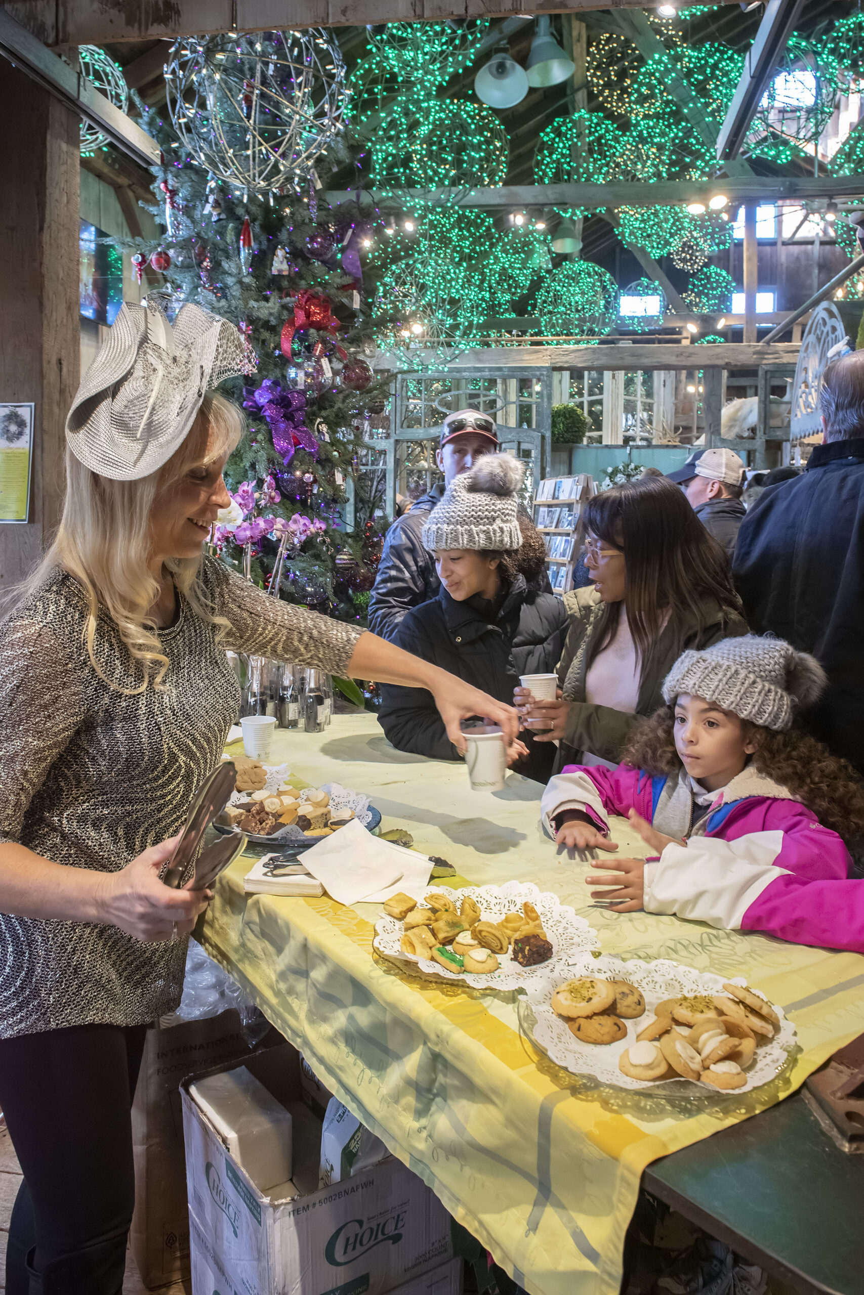 Laura Carlisle hands out cookies and cider to guests during the opening day of Marders Nursery Christmas Open House last year.  MICHAEL HELLER