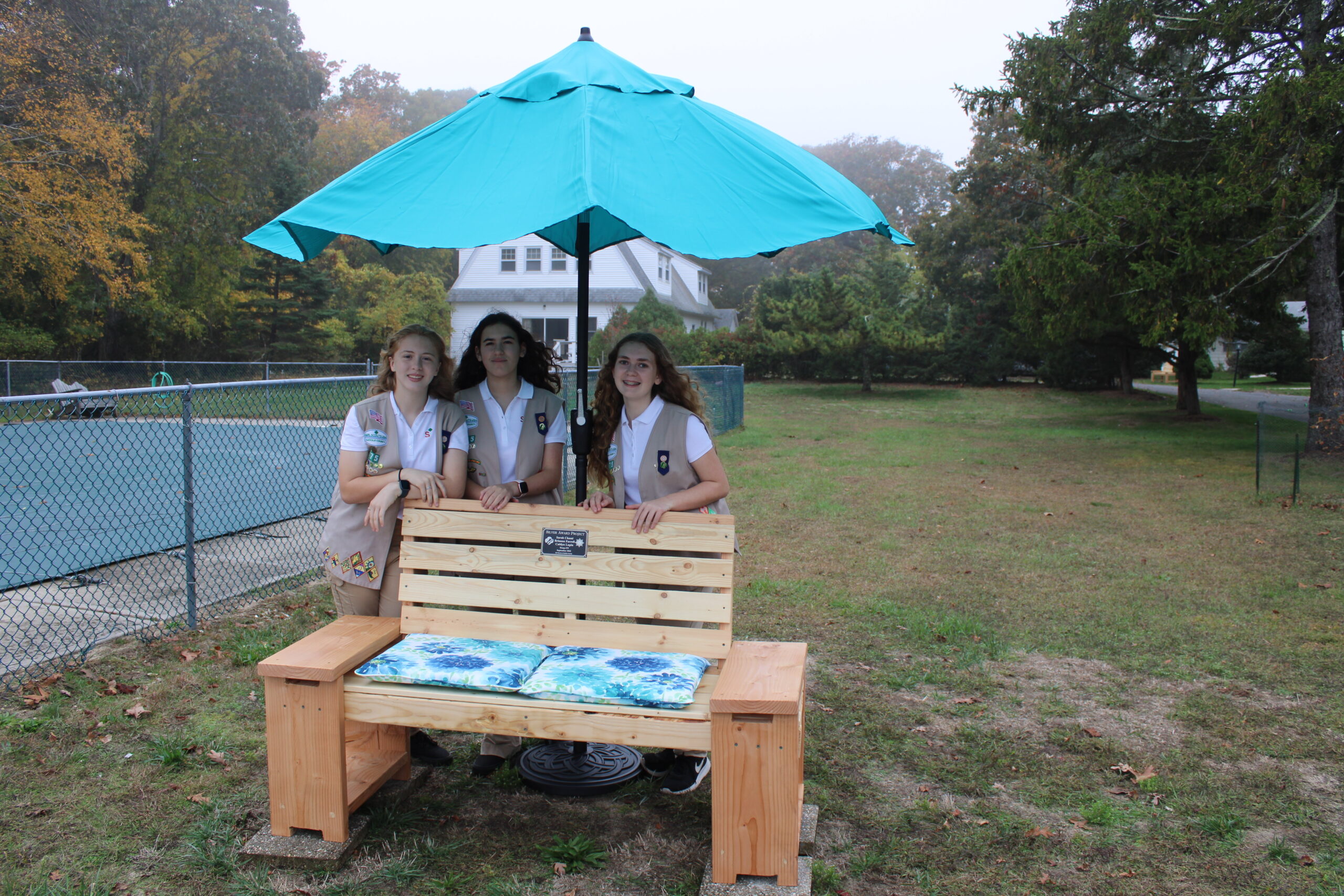 Brianna Farrell, Sarah Chami and Caitlyn Lupia posing near one of the benches they built for the nuns at St. Joseph's Villa. This specific bench overlooks the Shinnecock Bay.  ELIZABETH VESPE