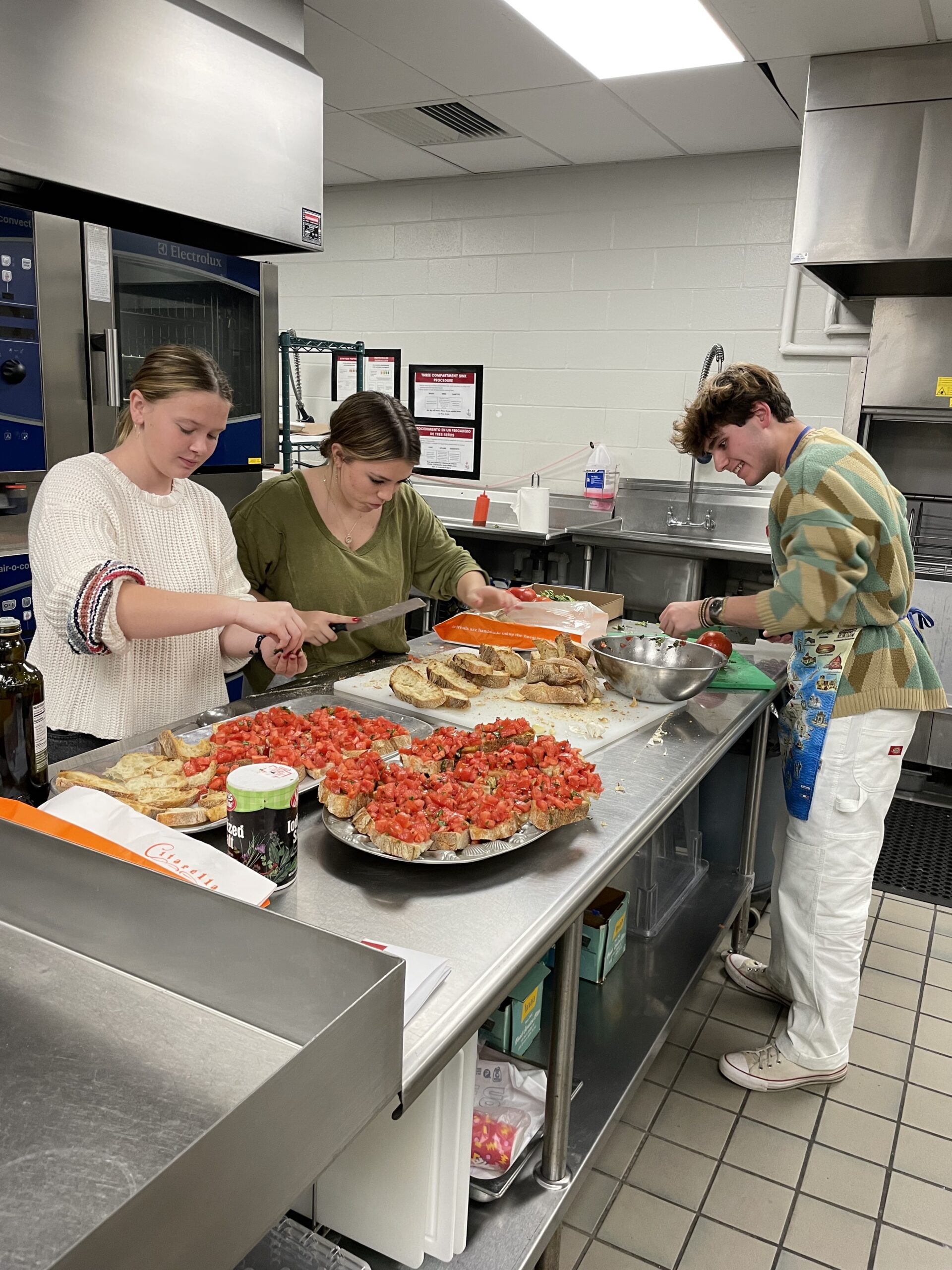 Southampton high School Italian Club members, including, from left, Shaye Meaney, Maggie Nydegger and JP Carrello, prepare bruschetta for the club’s first community Italian class. COURTESY SOUTHAMPTON SCHOOL DISTRICT