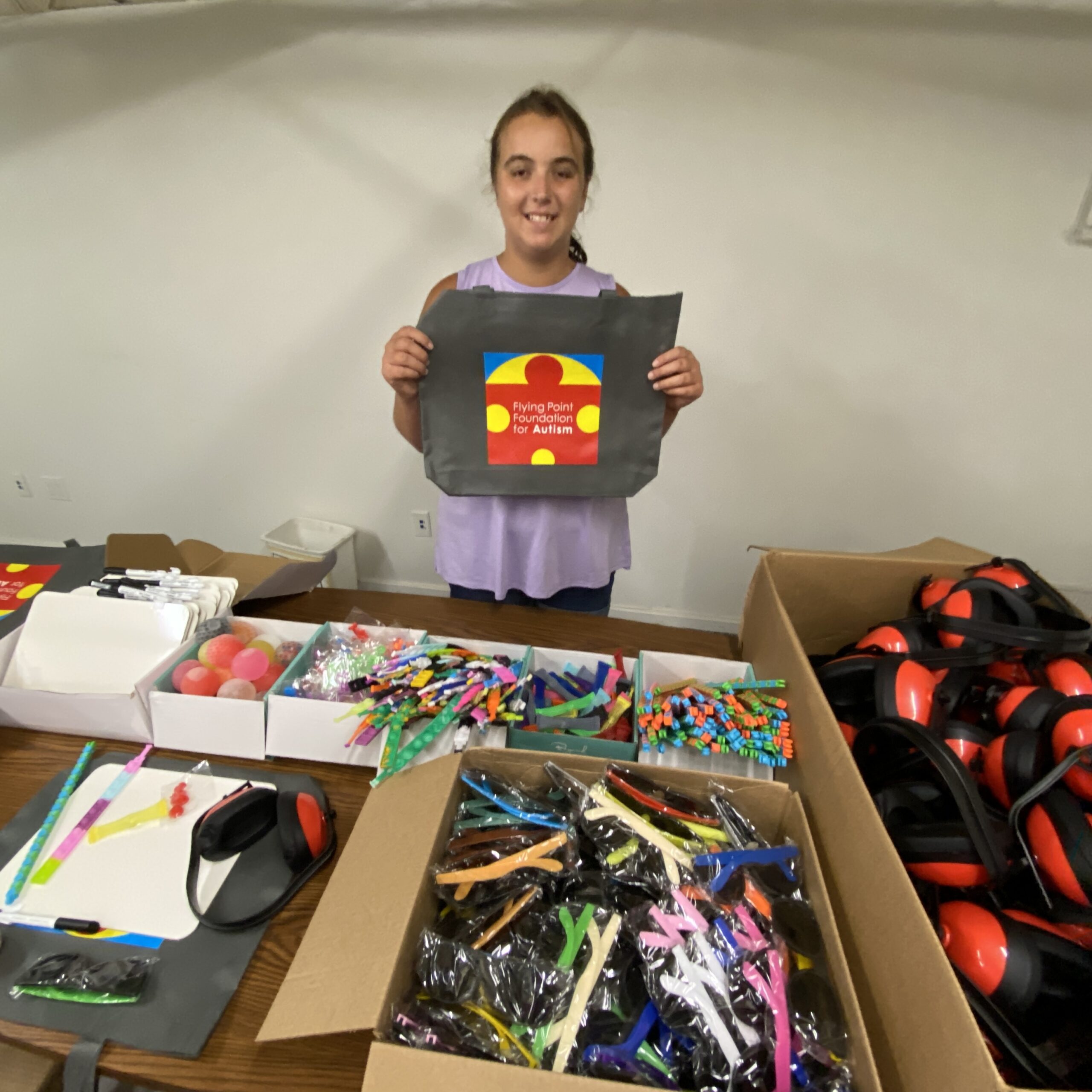 Anna Tuzzolo with the contents of GoBags she compiled for emergency responders. Recently the Flying Point Foundation for Autism distributed them to local police and ambulance companies. COURTESY FPF