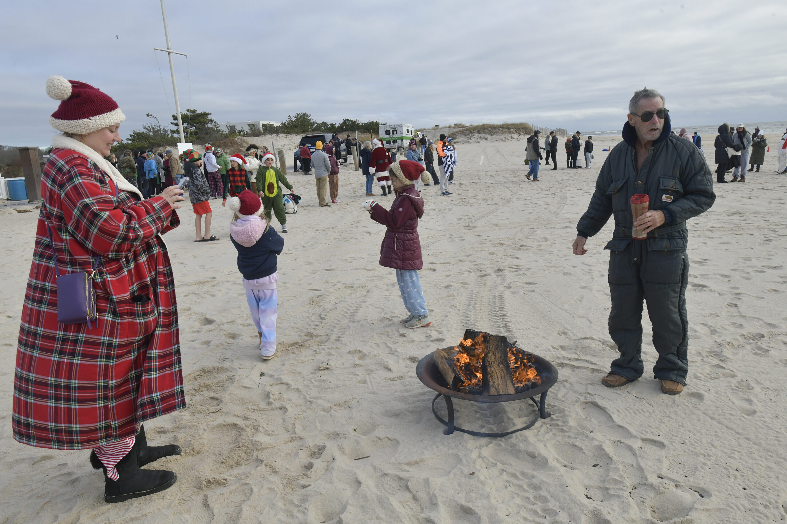 Folks keep warm prior to the annual Polar Bear Plunge at Coopers Beach on Saturday.  DANA SHAW