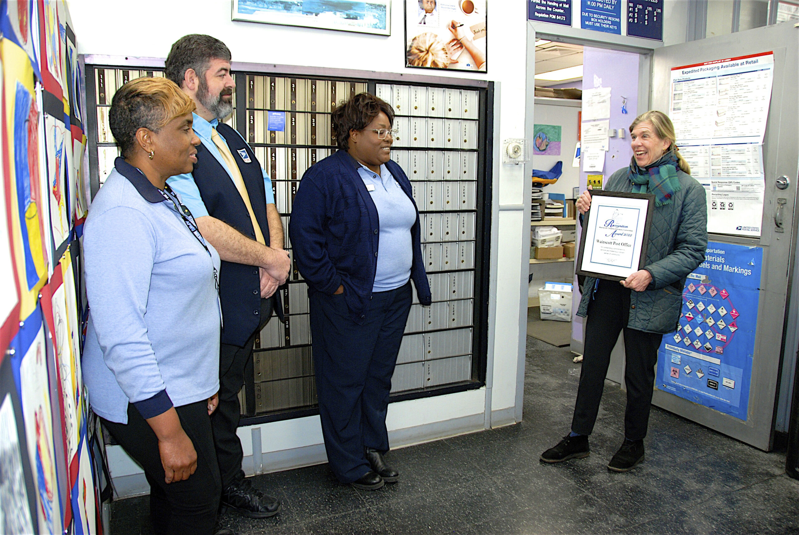 Wainscott Citizens Advisory Committee member Carolyn Logan Gluck, far right, presents the annual Wainscott Business Community Award to the Wainscott Post Office on Saturday to post office staff members  Susan Roddick, Morgan O’Connell, Brandii Sangster.     KYRIL BROMLEY