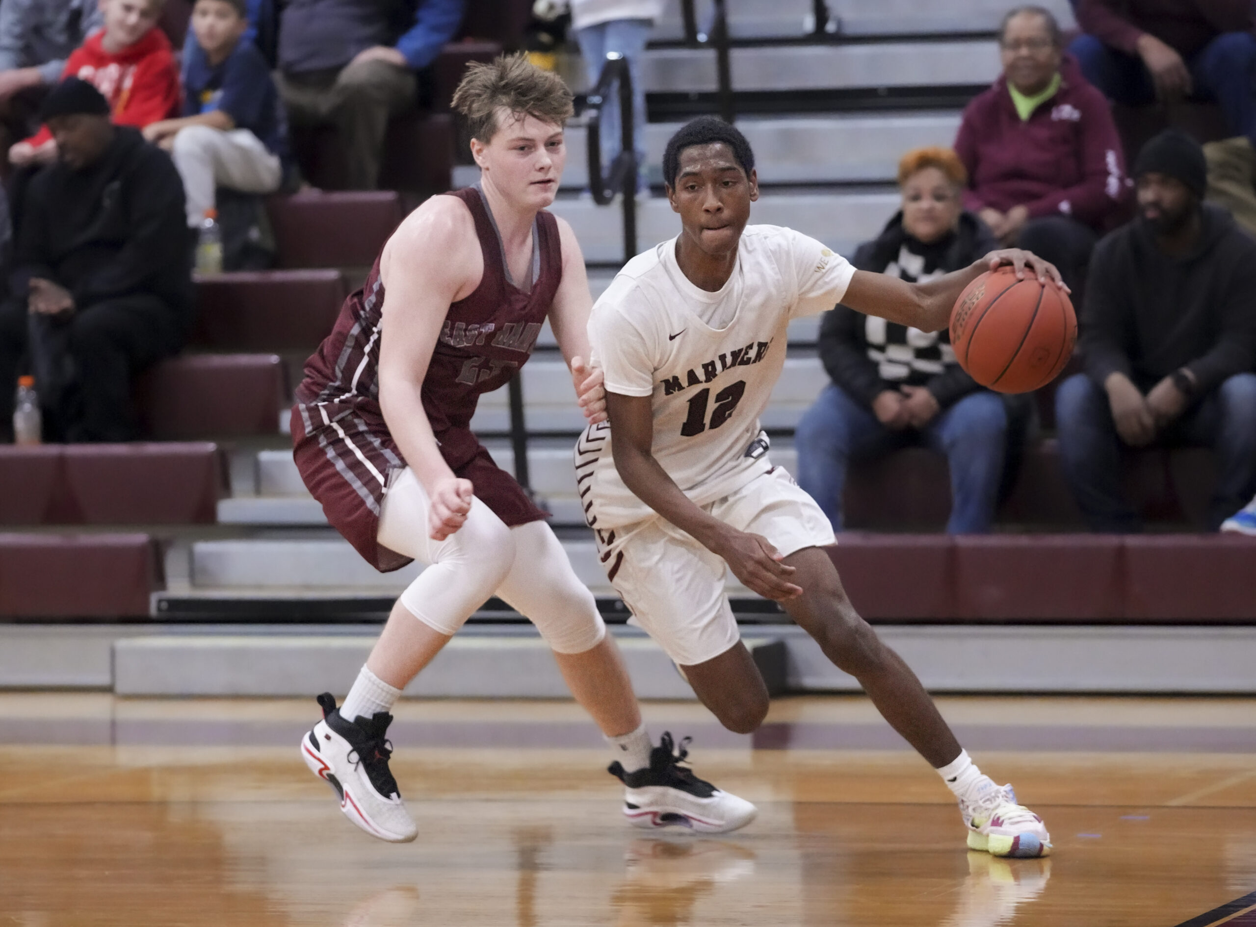 Mariner Tyrese Reddick drives passed East Hampton senior Nick Cardone.   RON ESPOSITO