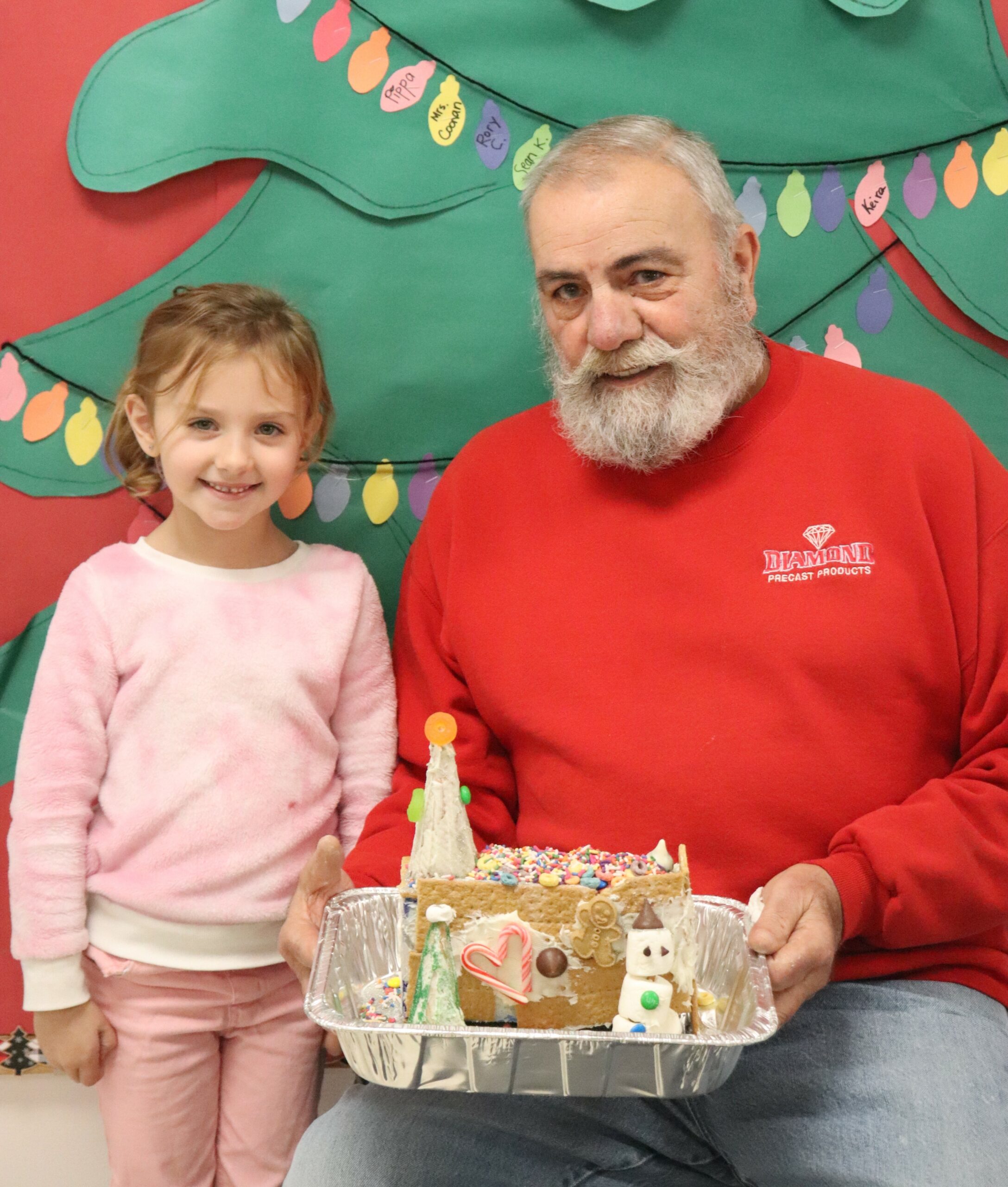 The preKindergarten students of Raynor Country Day School recently hosted their  annual gingerbread build for friends and family.  
Upon arrival, the teams received all the supplies and instructions needed to turn their icing, candies, sprinkles, and graham crackers into designer mansions, ski chalets, outdoor landscapes, and of course, gingerbread houses. Violet Crisci with her grandfather. COURTESY RAYNOR COUNTRY DAY SCHOOL