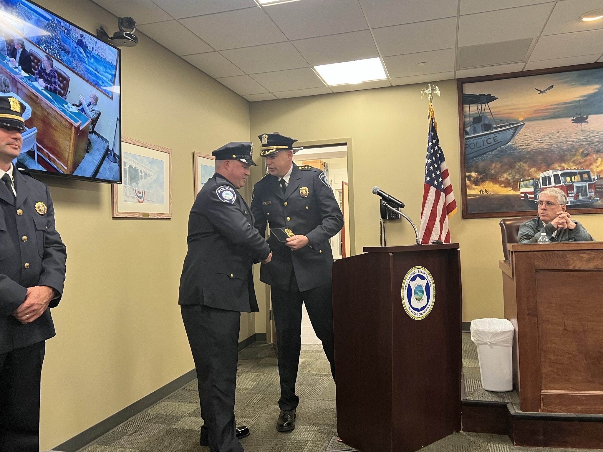 Sergeant Kevin Klokel is congratulated by Police Chief Steven McManus at the January 5 board meeting. BILL SUTTON