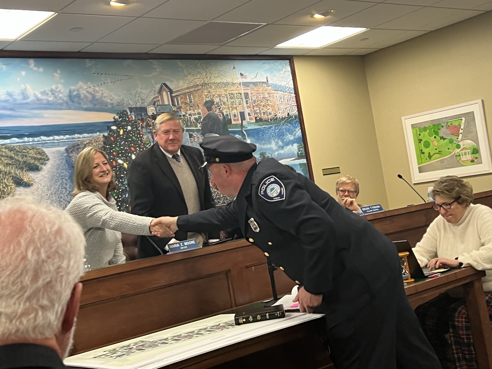 Sergeant Kevin Klokel is congratulated by Mayor Maria Moore at the January 5 board meeting. BILL SUTTON