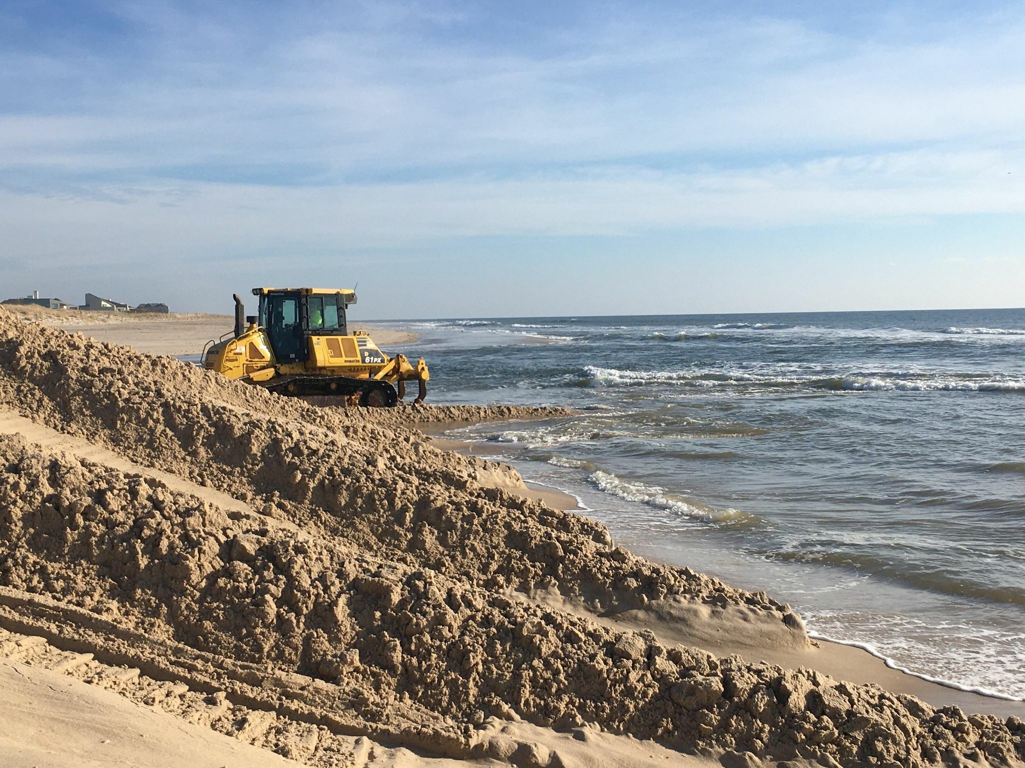 Out in the surf, the bulldozer crafts a sand mountain at the Mecox cut.    KITTY MERRILL