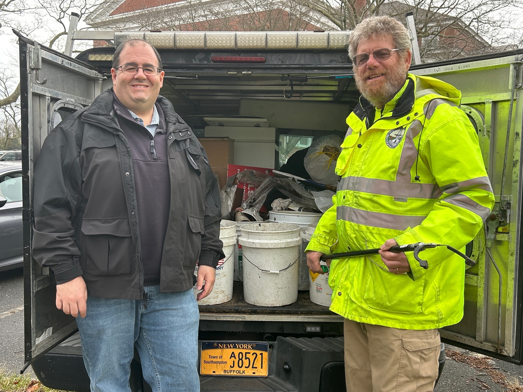 Holding his trusty picker, Dave Lipman poses with Southampton Town Public Safety Administrator Ryan Murphy in front of the morning's haul.    KITTY MERRILL