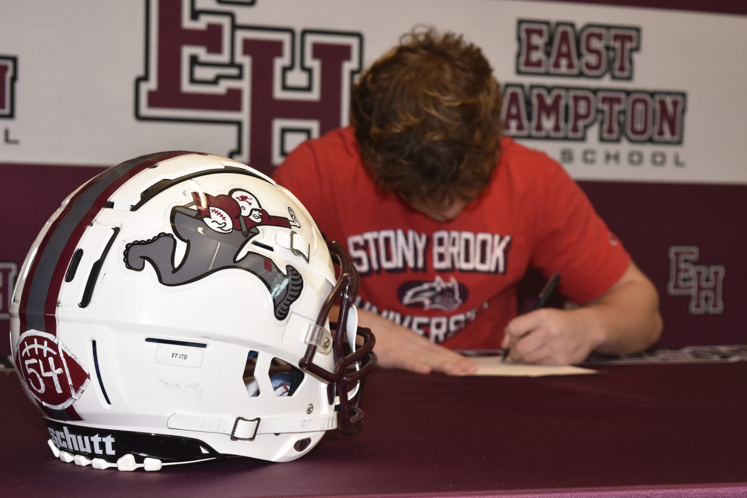 East Hampton senior Finn Byrnes signs his letter of intent to play Division I football at Stony Brook University on Thursday, February 2.   DREW BUDD