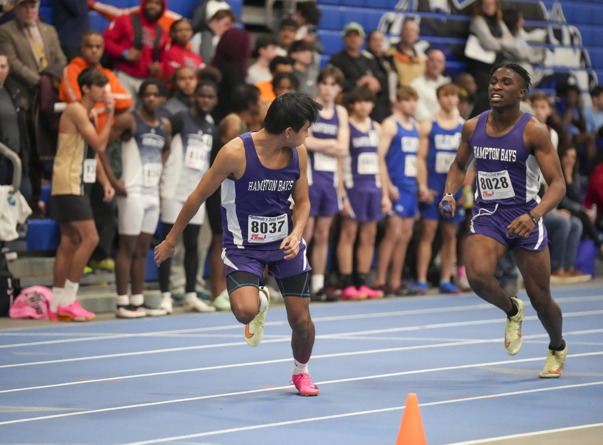 Eli Amos is about to hand off the baton to Baymen teammate Charlie Garcia in the 4x200-meter relay.   RON ESPOSITO