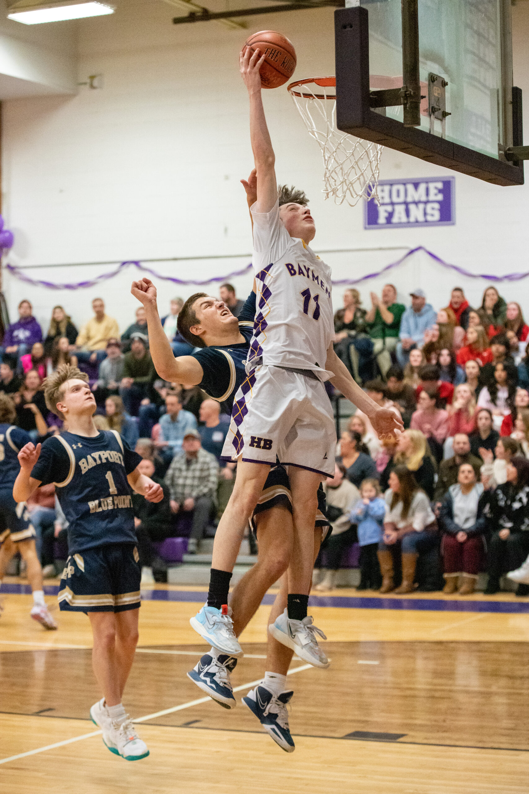 Junior small forward Pat Donahue places the ball in the hoop with defenders on his back. MICHAEL O'CONNOR