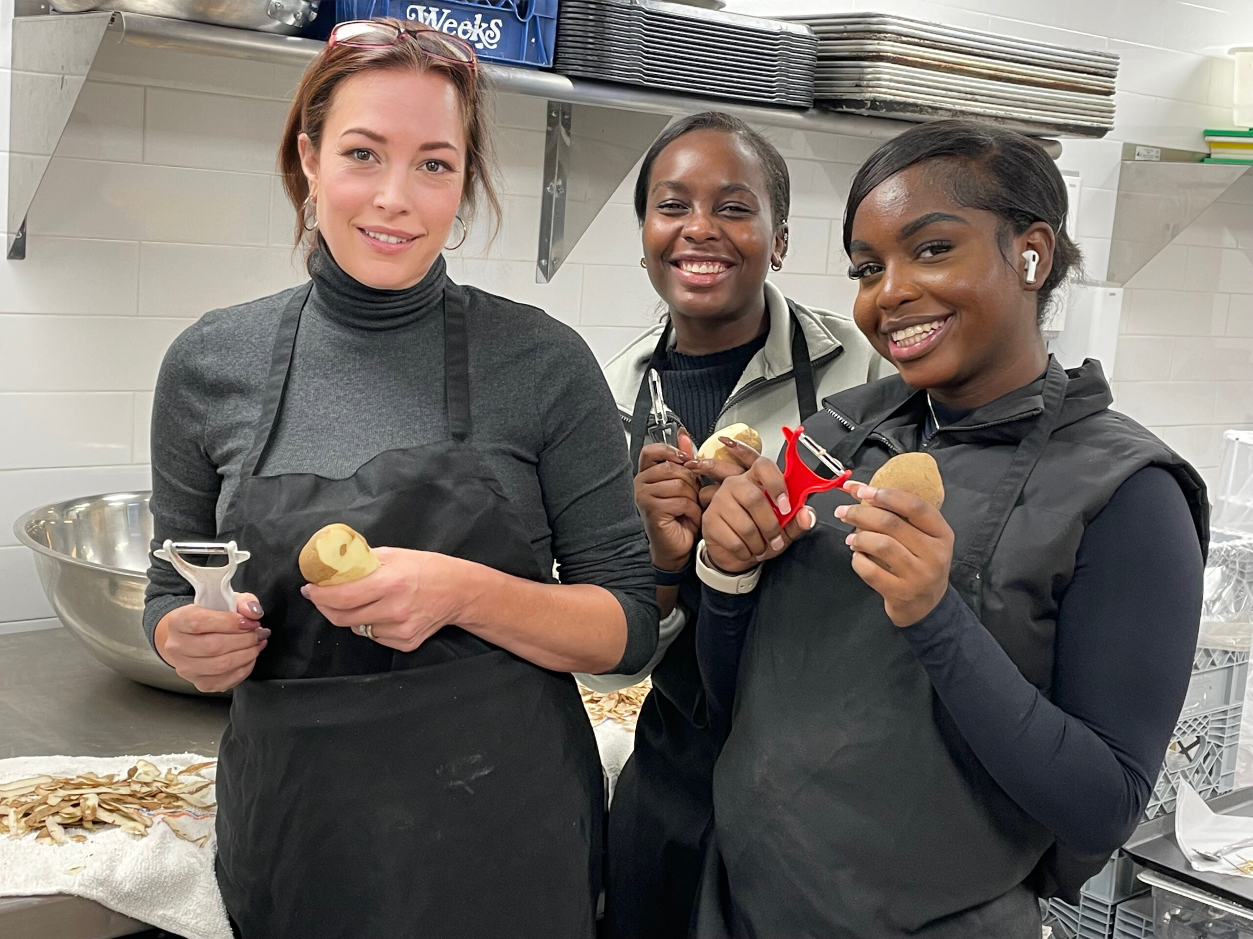 East End Women's Network President Katherine Pierro and members Madlie and Skerly Armand prepare food for a Thanksgiving charity event. COURTESY KATHERINE PIERRO