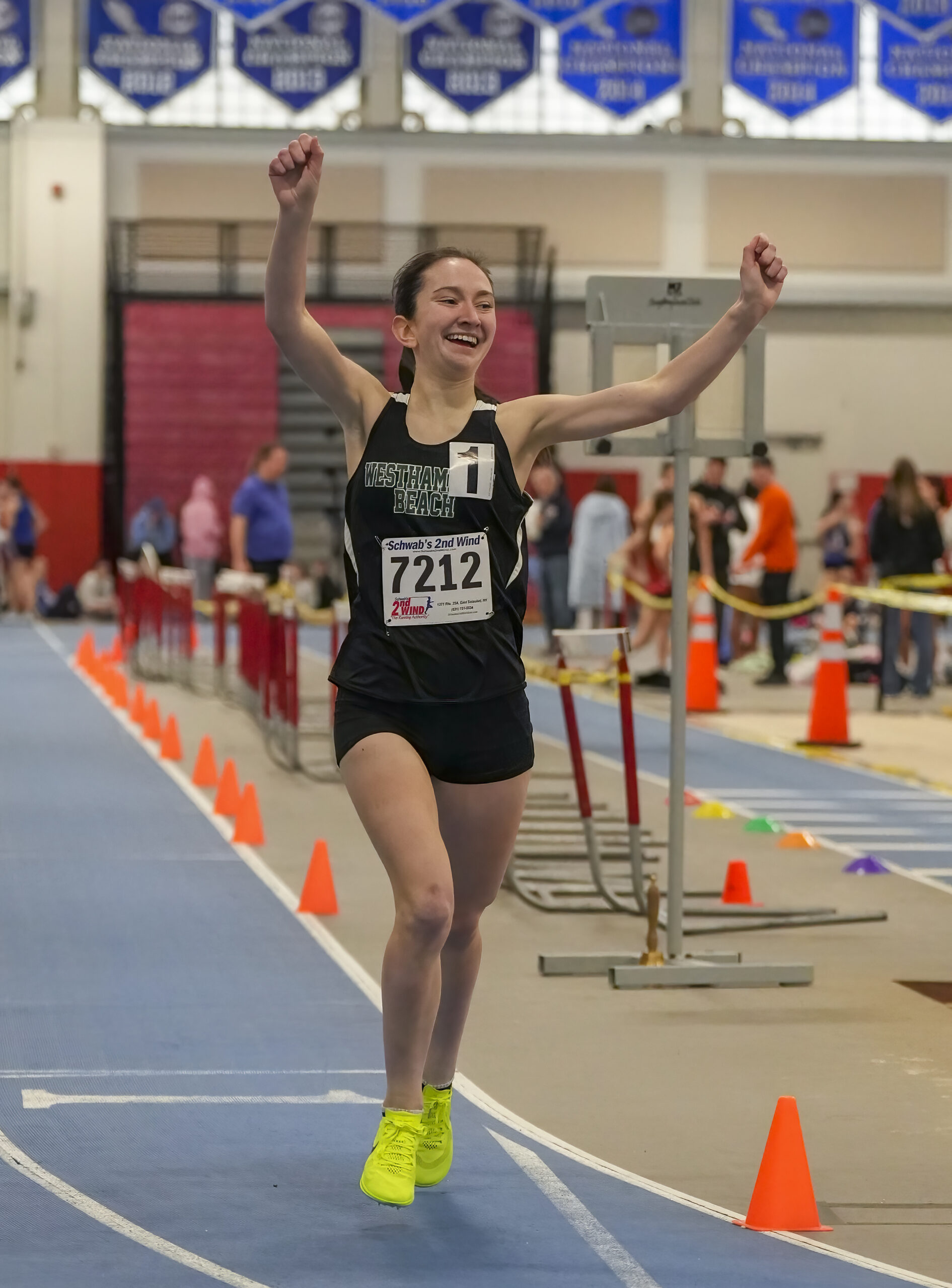 Westhampton Beach sophomore Lily Strebel raises her arms after winning the 1,000-meter race.   RON ESPOSITO