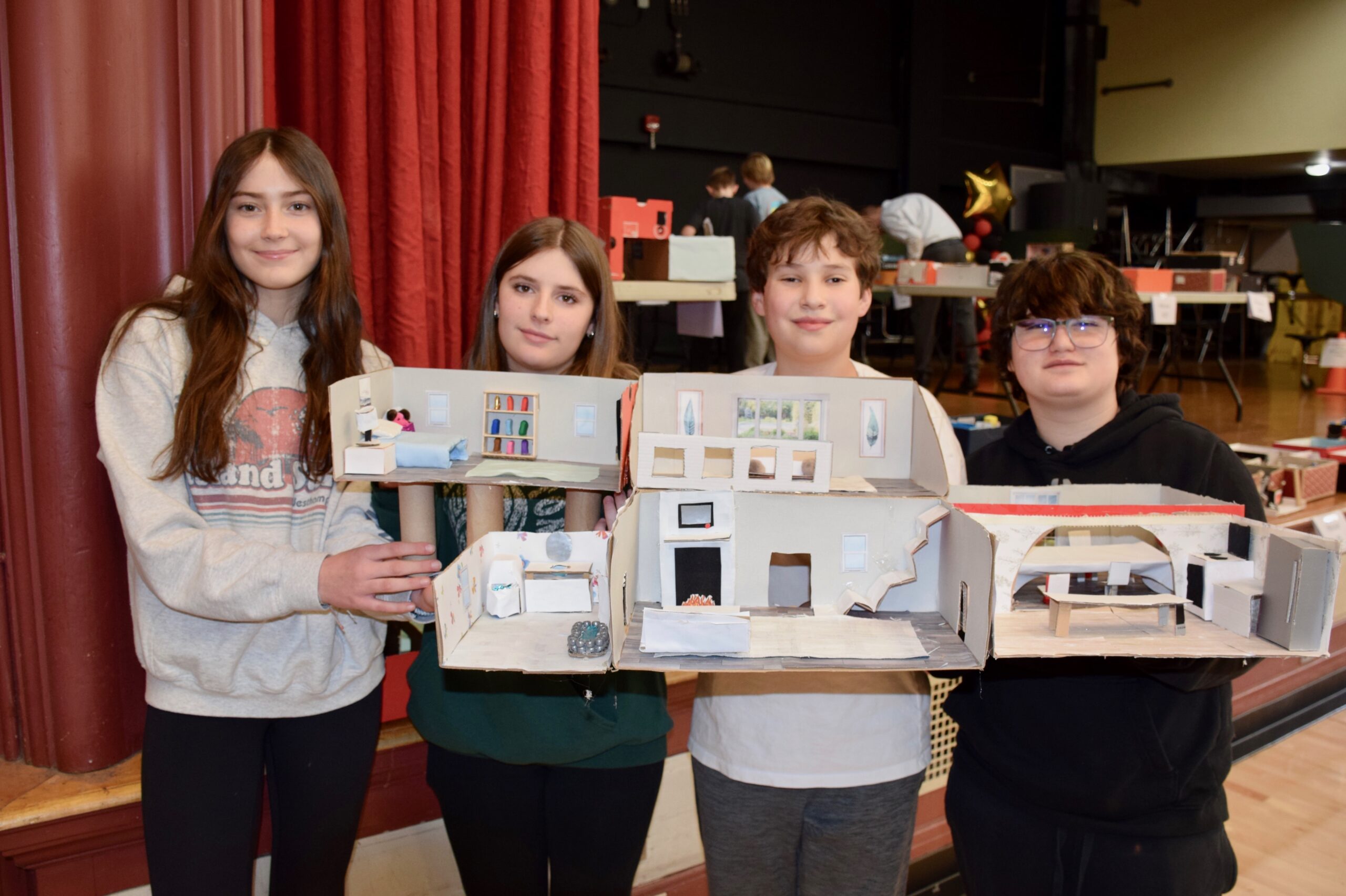 Westhampton Beach Middle School students in Kathleen Ciancio’s seventh grade family and consumer sciences class recently created interior design projects. For the hands-on project, the students worked in groups to sketch drawings of the layout of their homes and then used shoeboxes, craft supplies and recycled materials to complete the projects, which were then displayed in the school cafeteria.  From left,  Chloe Blowes, Penelope Huhn, William Sultan and Aaron Weidel. COURTESY WESTHAMPTON BEACH SCHOOL DISTRICT