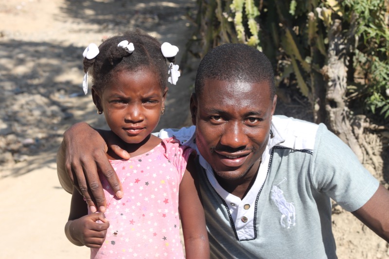 Doctor Gueslin Joassanvil (Medical Center director) and a young child, outside the clinic in Fiervil. 