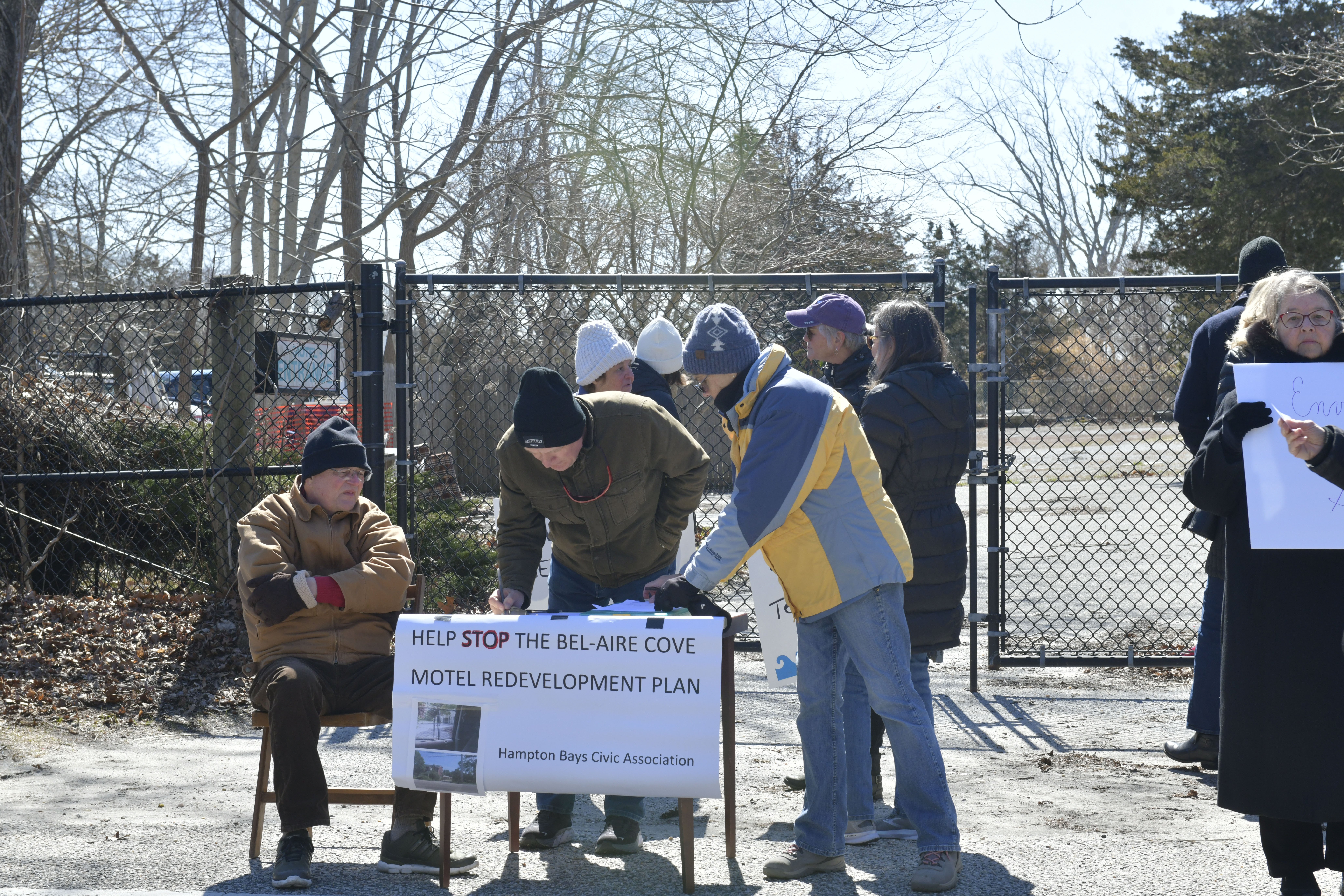 Protesters sign a petition at the former Bel-Aire Cove Motel site on Sunday.  DANA SHAW