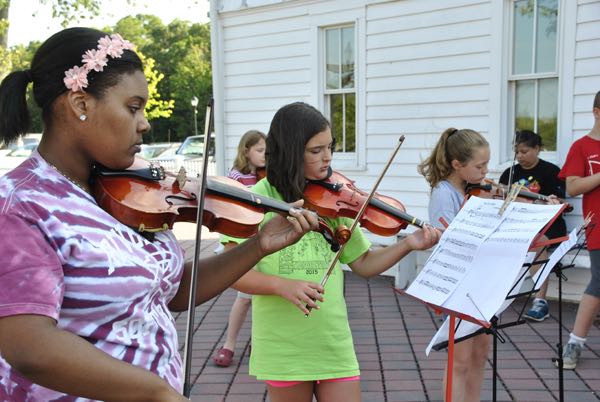 A group violin lesson through East End Arts