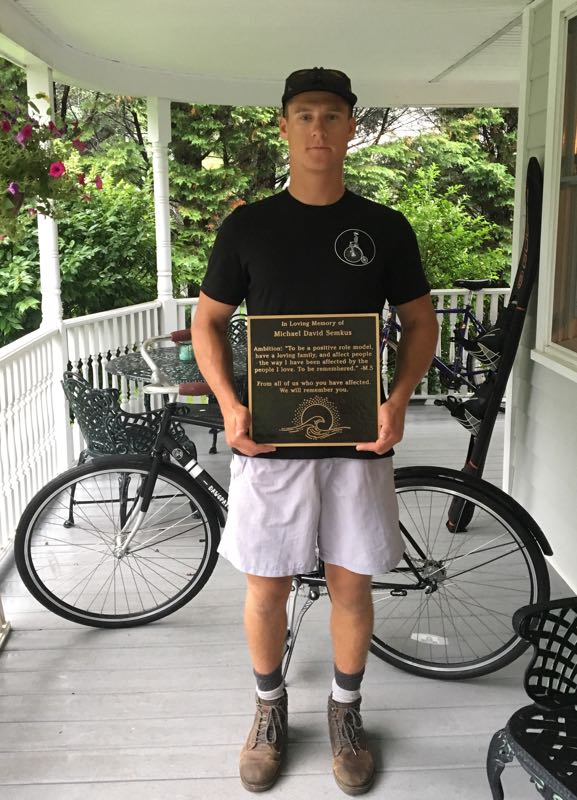 Drew Harvey holding a plaque honoring his friend