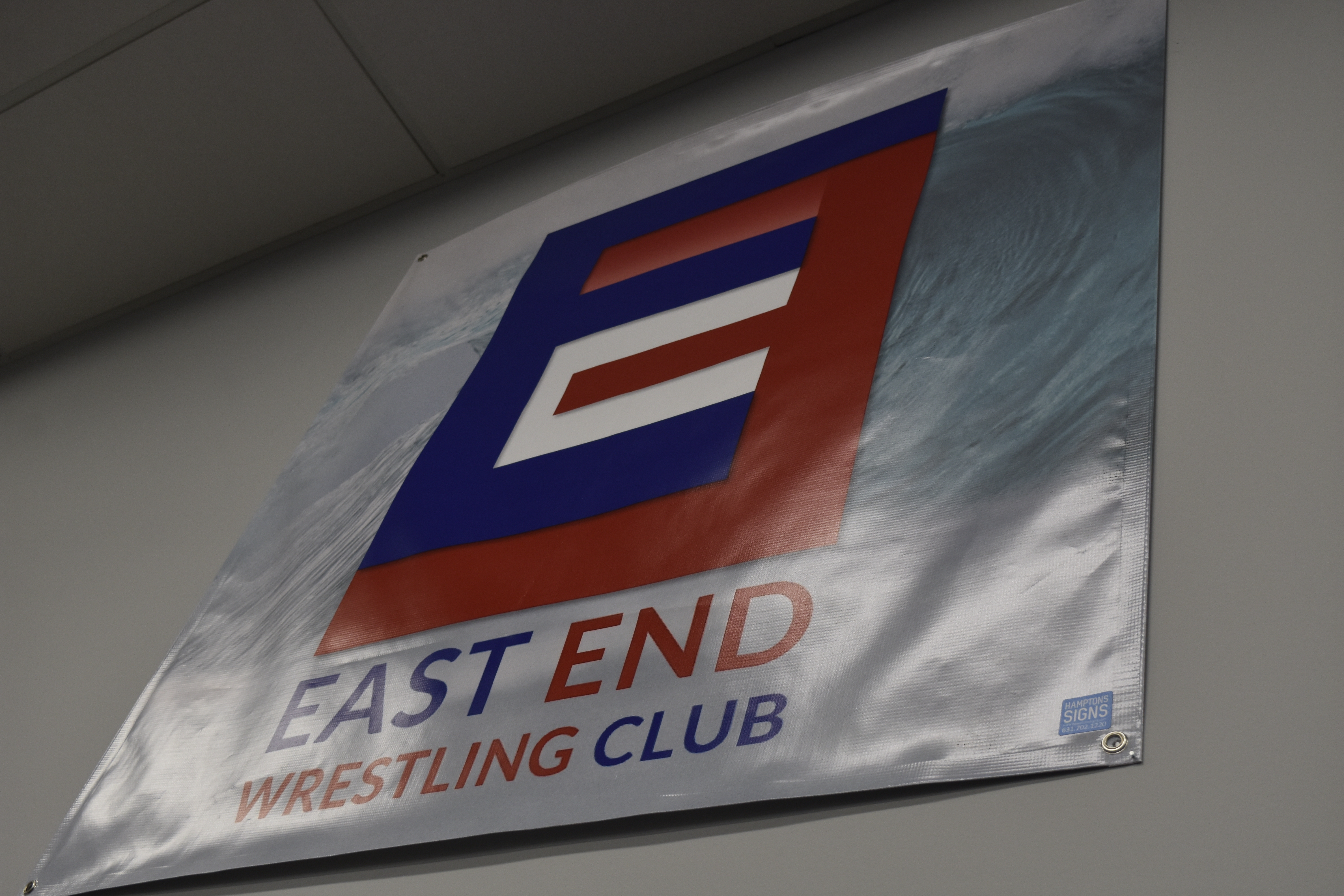 The East End Youth Wrestling banner hangs up within the walls of Hamptons Jiu-Jitsu in Southampton.   DREW BUDD