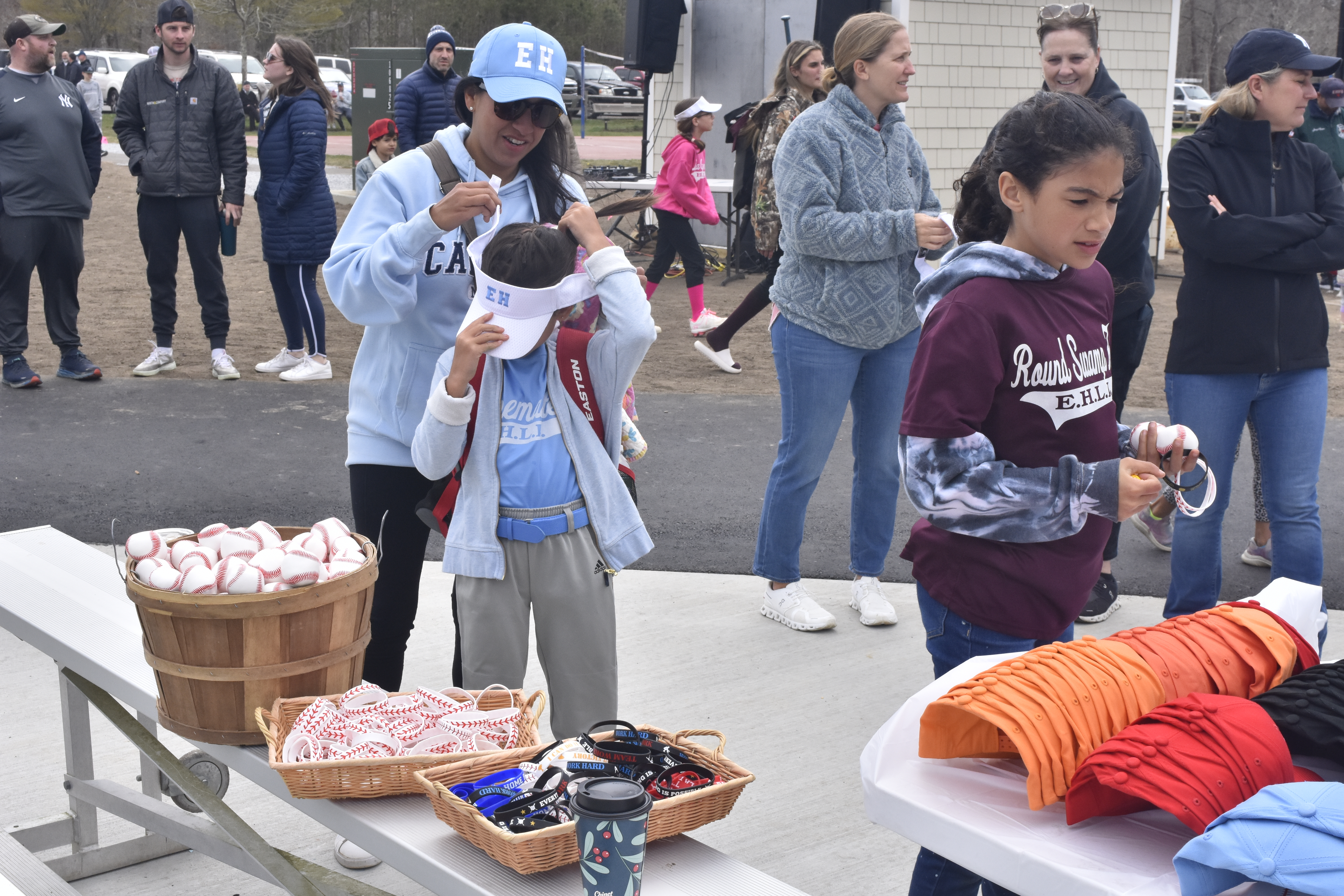 Players and parents pick up their hats and uniforms in addition to some other swag.   DREW BUDD