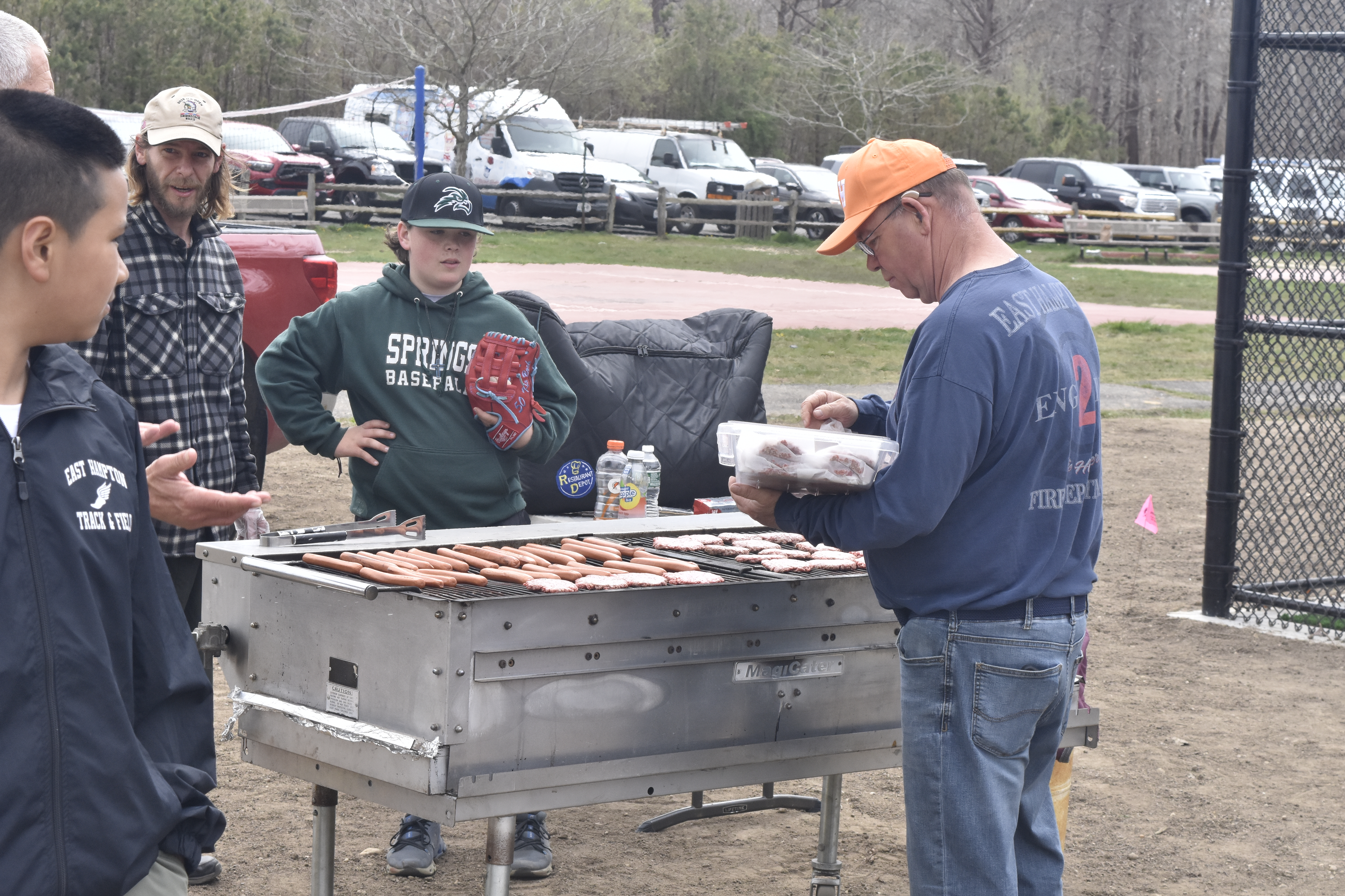 The hot dogs and hamburgers go on the grill.   DREW BUDD