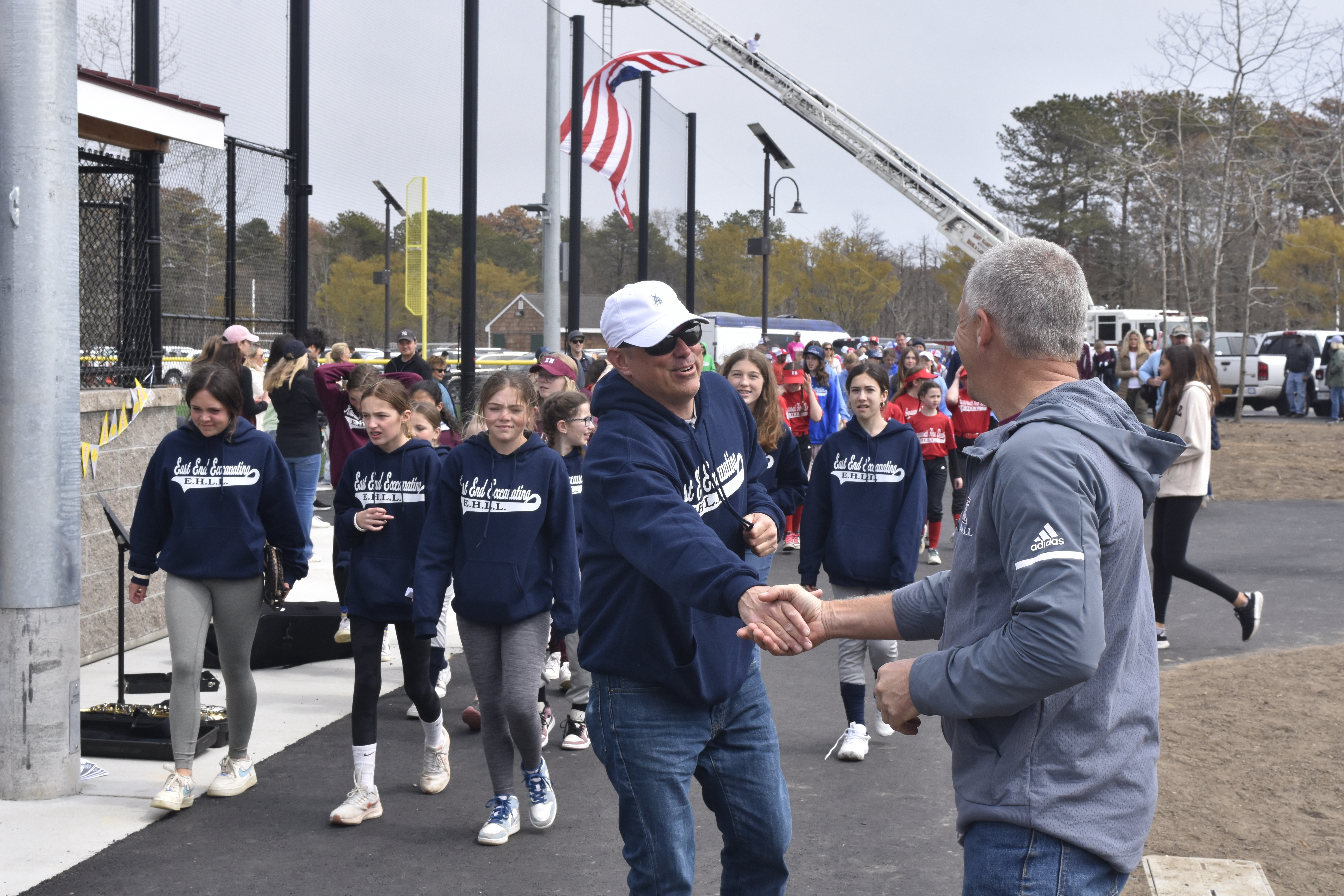 East Hampton Little League Vice President Dave Rutkowski directs players and coaches on to the field.   DREW BUDD