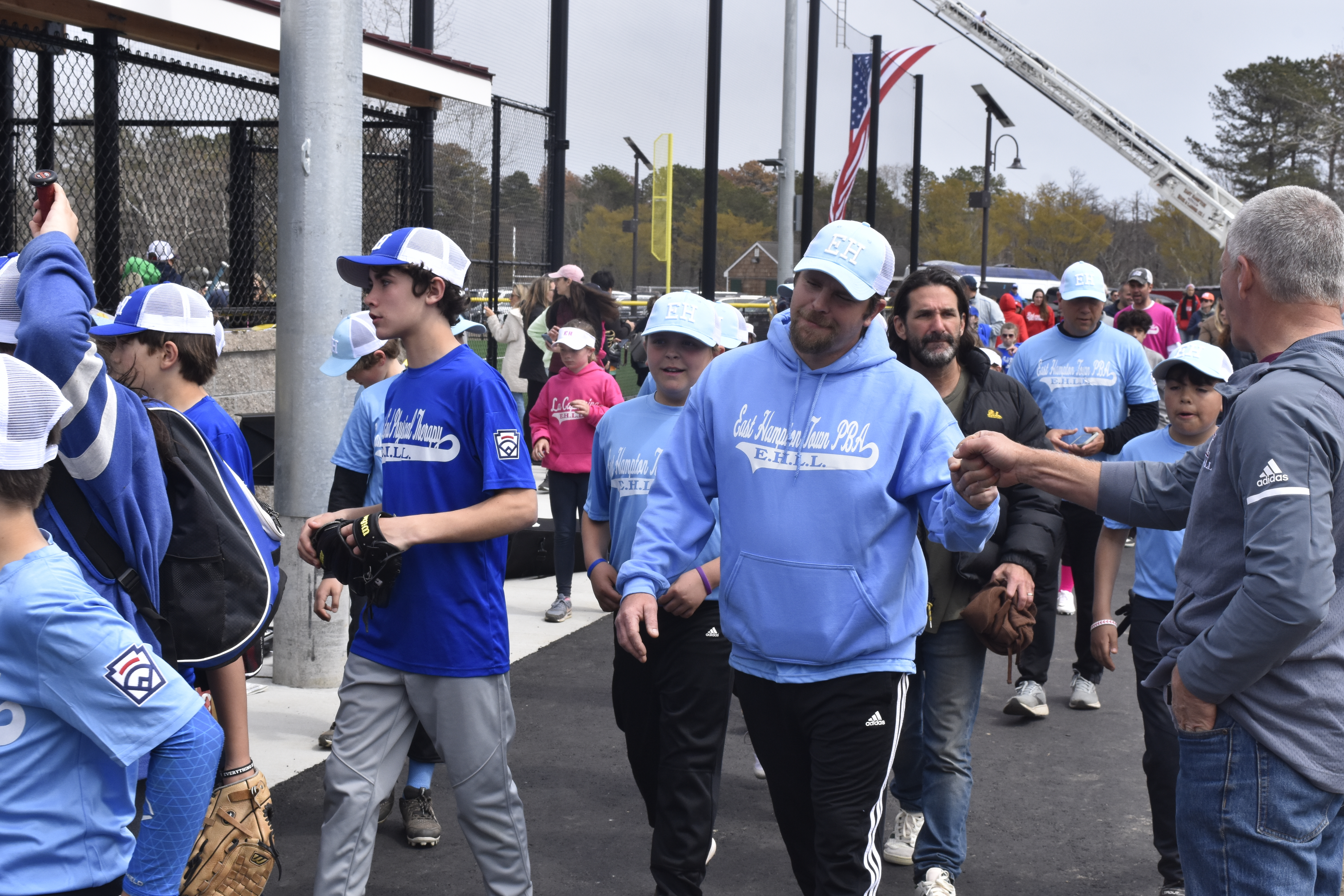 East Hampton Little League Vice President Dave Rutkowski directs players and coaches on to the field.   DREW BUDD