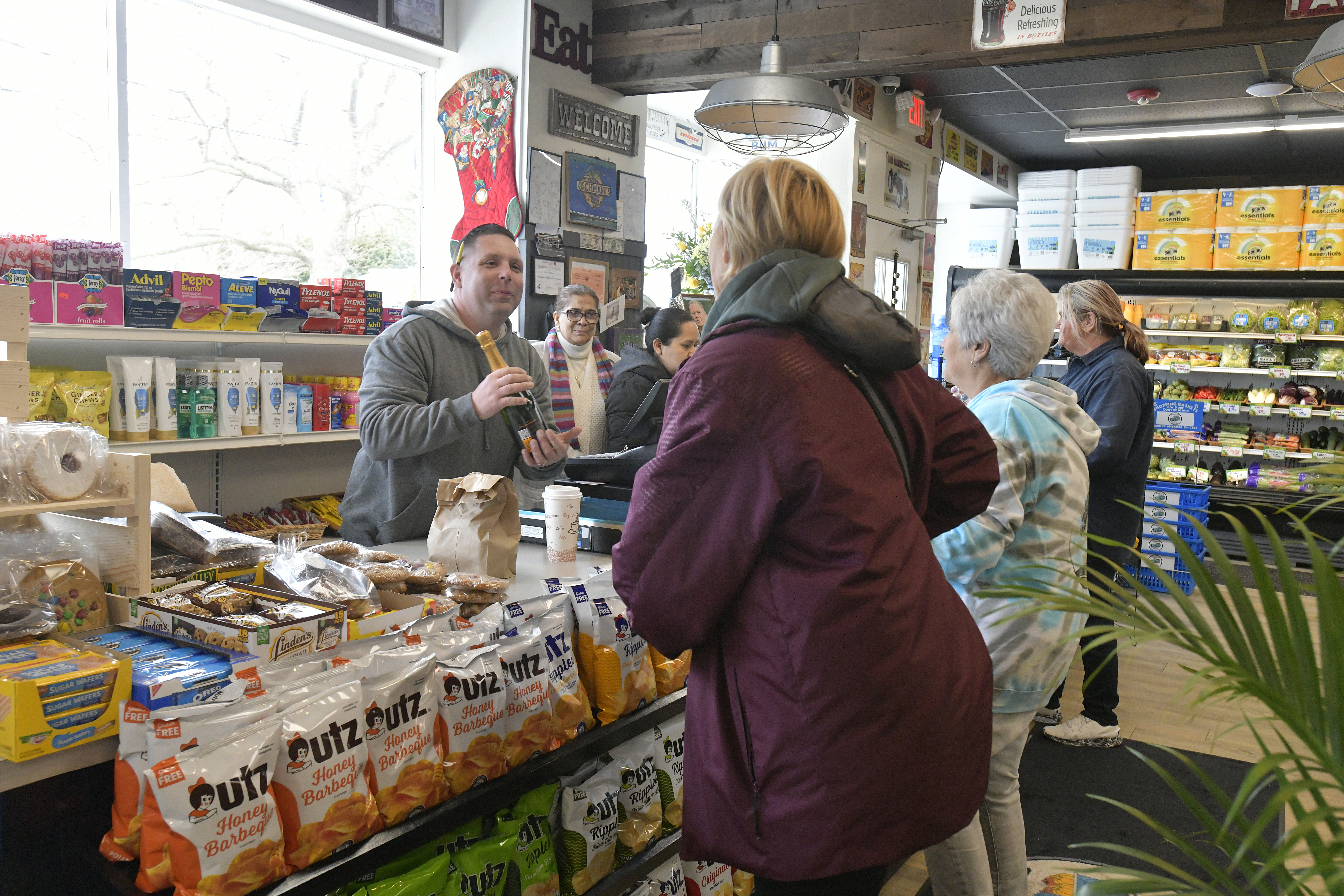 Dan Schmidt receives a bottle of champagne from a well wisher at the opening day of Schmidt's Country Market in Quogue on March 31.  DANA SHAW