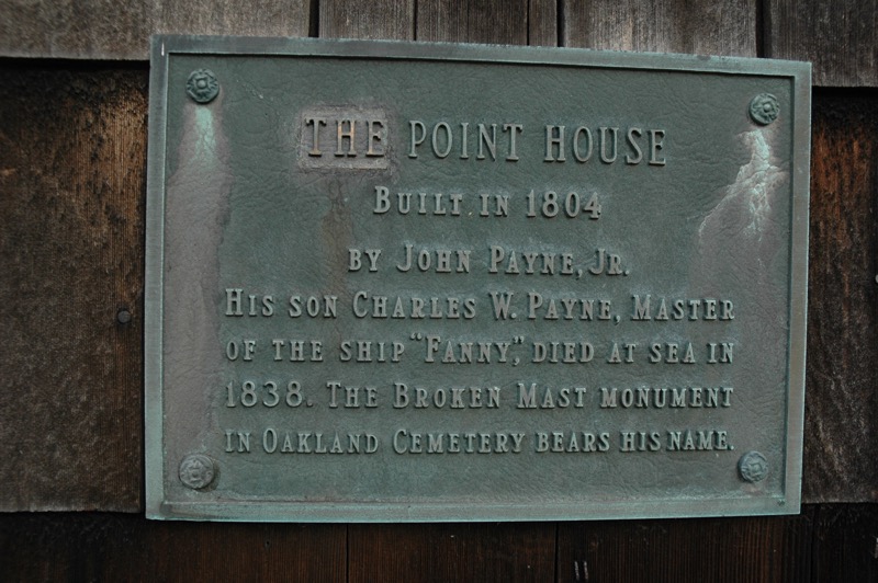 A plaque with details about the Point House hangs on the outside of the building. 