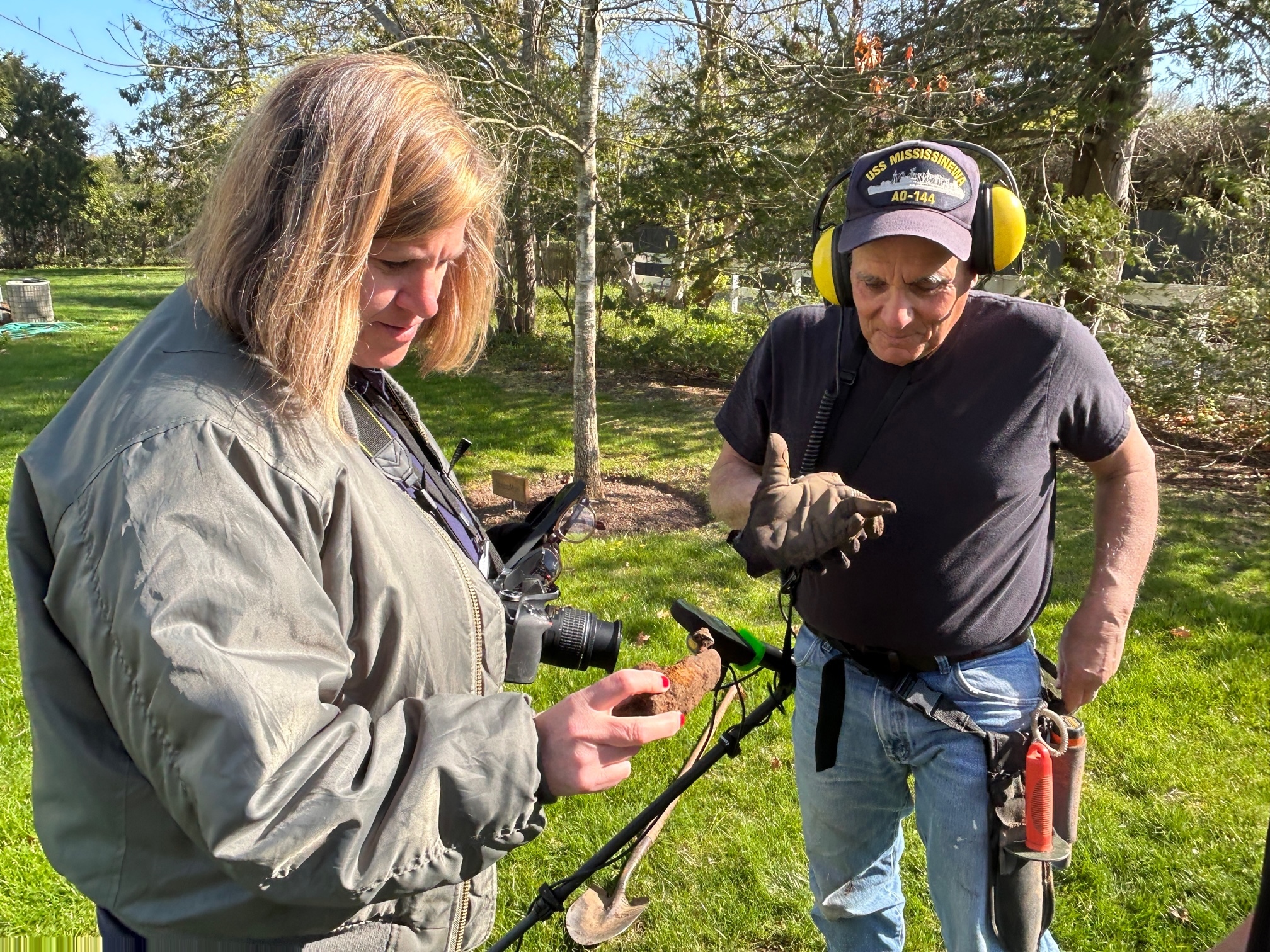 Southampton Town Historian Julie Greene checks out a piece of metal dug up during Larry Andria's search for artifacts at Remsenburg Academy.    KITTY MERRILL