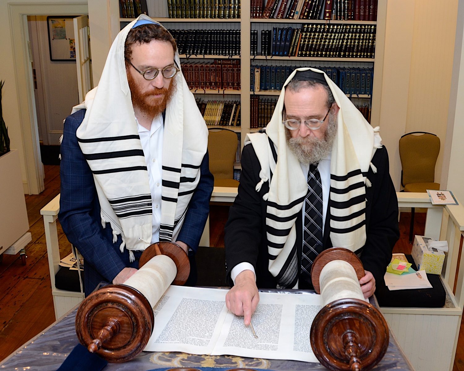 Chabad of the Hamptons Rabbi Leibel Baumgarten reads from the Torah as his son, Assistant Rabbi Aizik Baumgarten, looks on. KYRIL BROMLEY