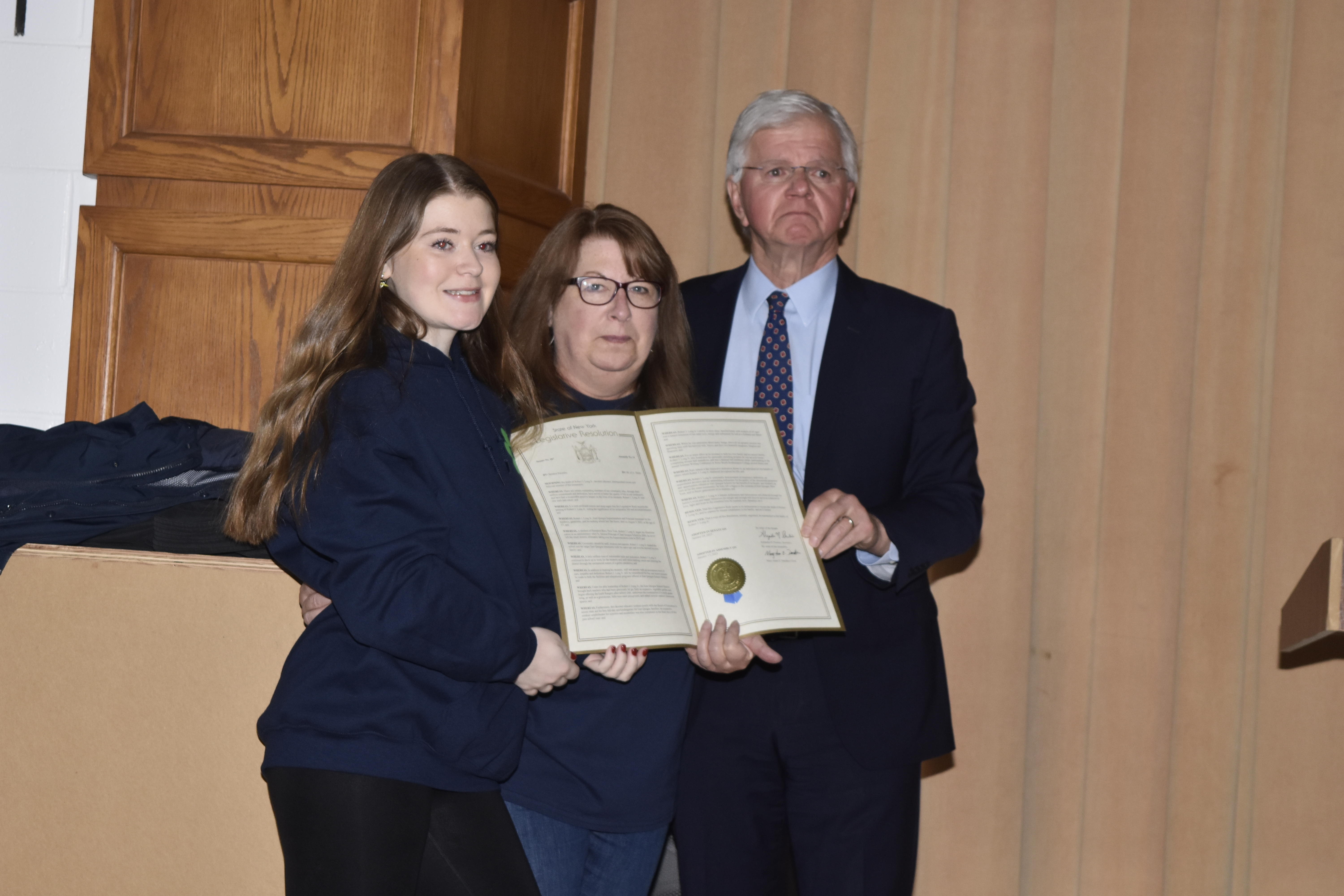 State Assemblyman Fred W. Thiele Jr. presented a New York State resolution that was passed in January to Rob Long's wife Dawn and daughter Meghan.   DREW BUDD