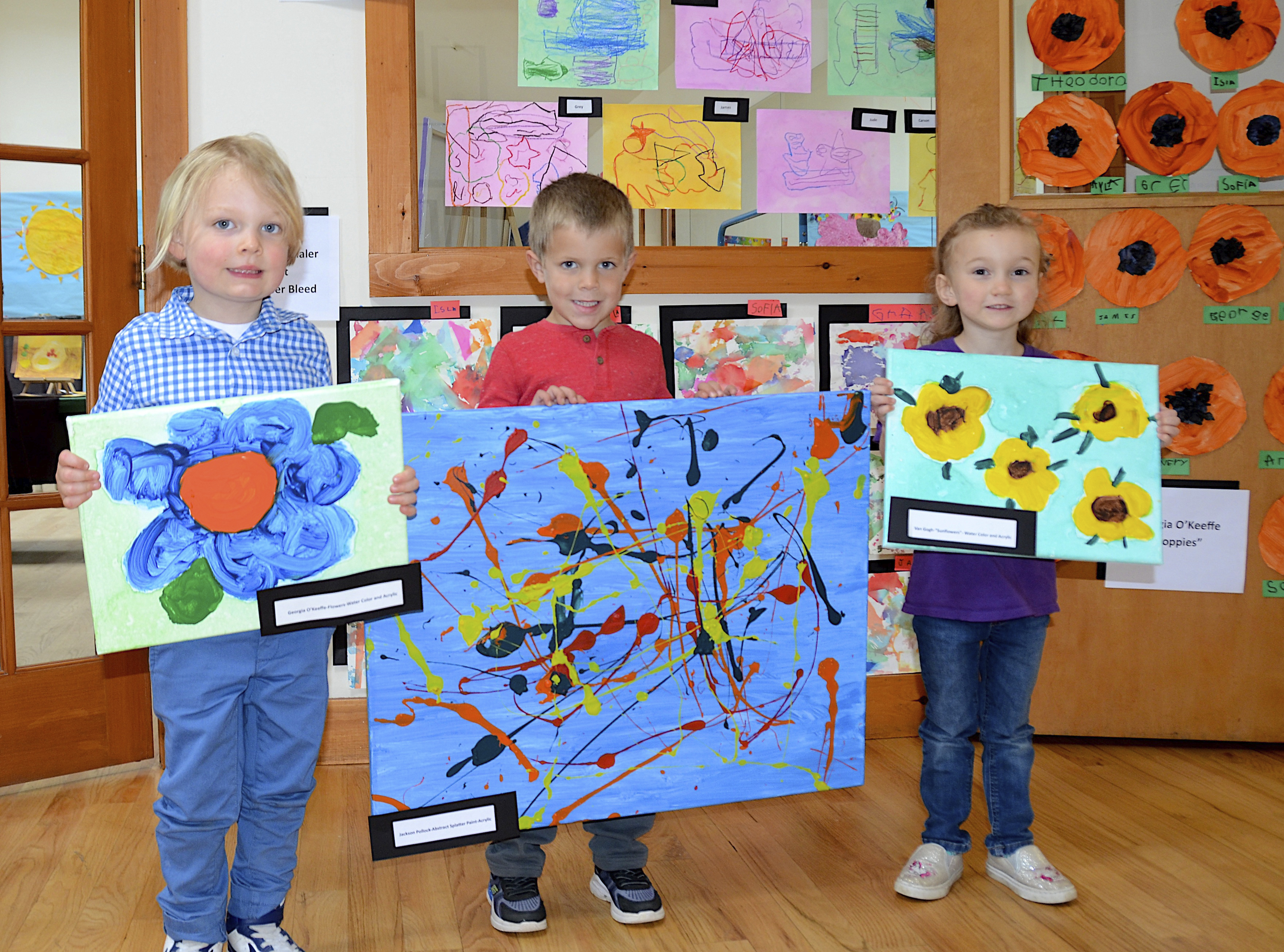 Grant Steyert, Sawyer Payne and Ayla Jarvis with their artwork at the Country School's student art showcase on Friday in Wainscott, featuring the  Pre-K class lead by teachers Marigrace Ryan and Lisa Prevete.    KYRIL BROMLEY