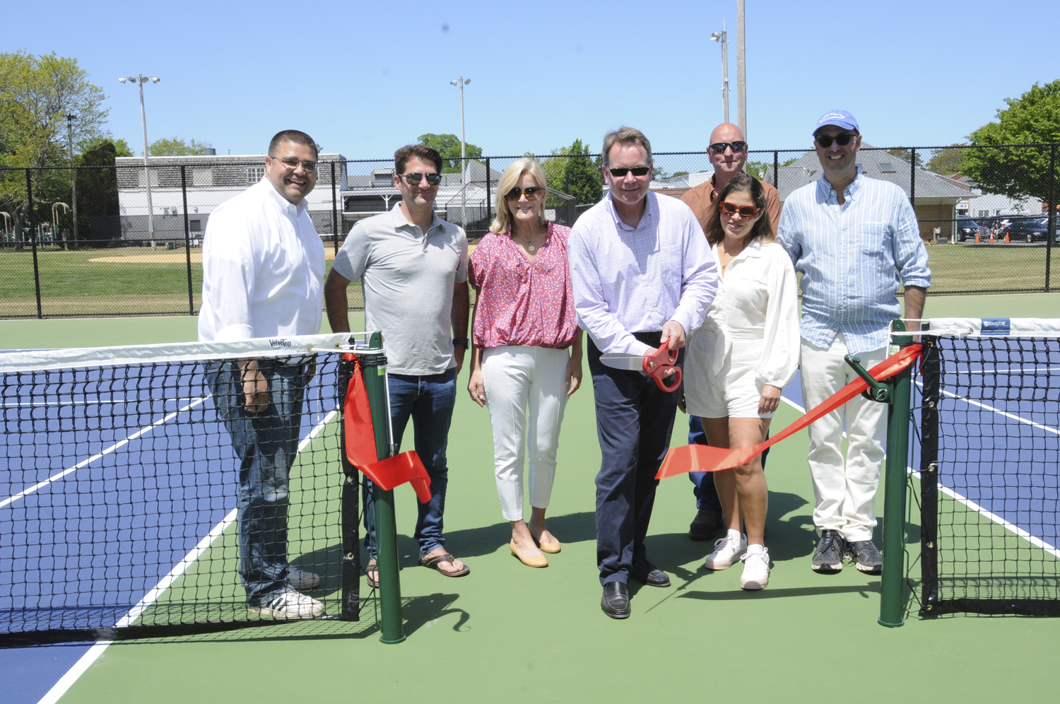 East Hampton Village Administrator Marcos Baladron; Village Deputy Mayor Chris Minardi; Village Trustee Sarah Amaden, Village Mayor Jerry Larsen; Village Trustee Sandra Melendez; Village Foundation Chairman and CEO Bradford Billet and, rear, Village Department of Public Works Superintendent David Collins cut the ribbon on the reconstructed tennis court in Herrick Park on Saturday to announce the completion of 