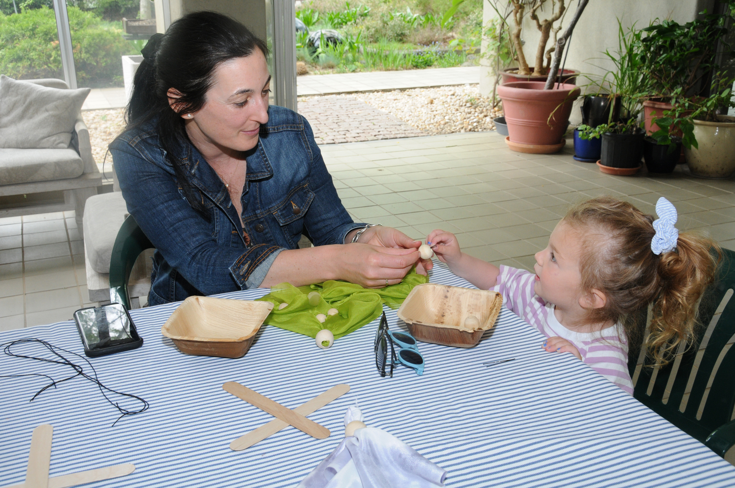 Mariah Whitmore and Waverly Grau make a marionette at LongHouse Reserve in East Hampton on Saturday. Kim Profaci of the The Marionette Company put on a marionette performance and helped attendees choose supplies to make their own .  RICHARD LEWIN