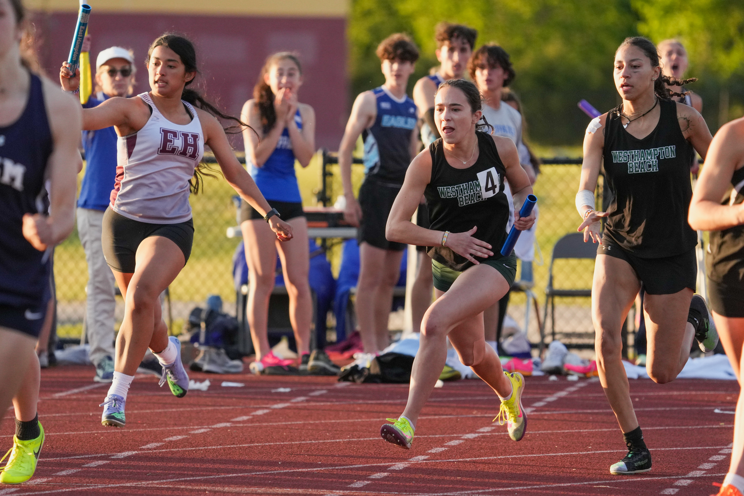 Halle Geller takes the baton from her Hurricane teammate Kylah Avery in the 4x100-meter relay.   RON ESPOSITO