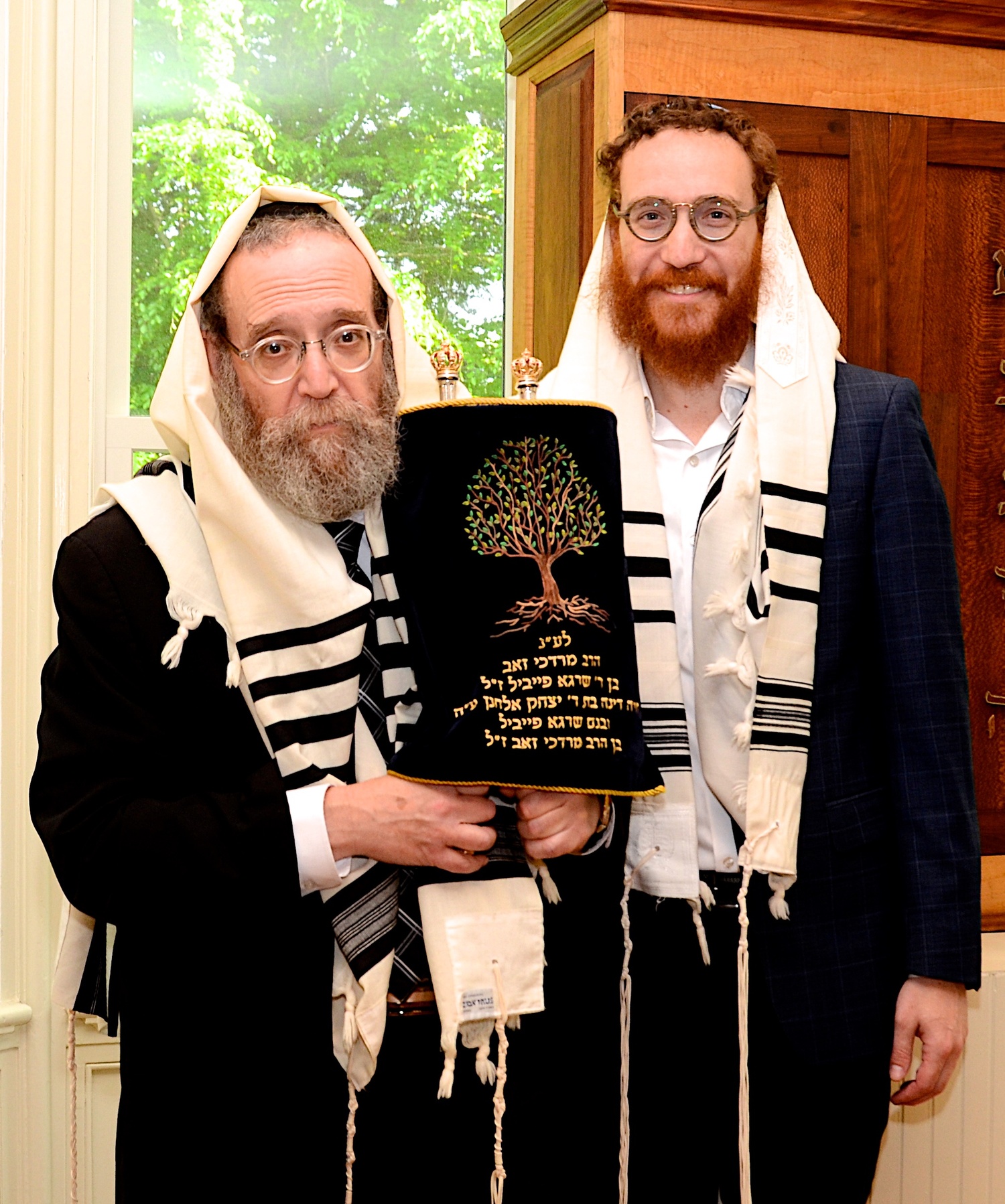 Chabad of the Hamptons Rabbi Leibel Baumgarten holds the Torah with his son, Assistant Rabbi Aizik Baumgarten. KYRIL BROMLEY