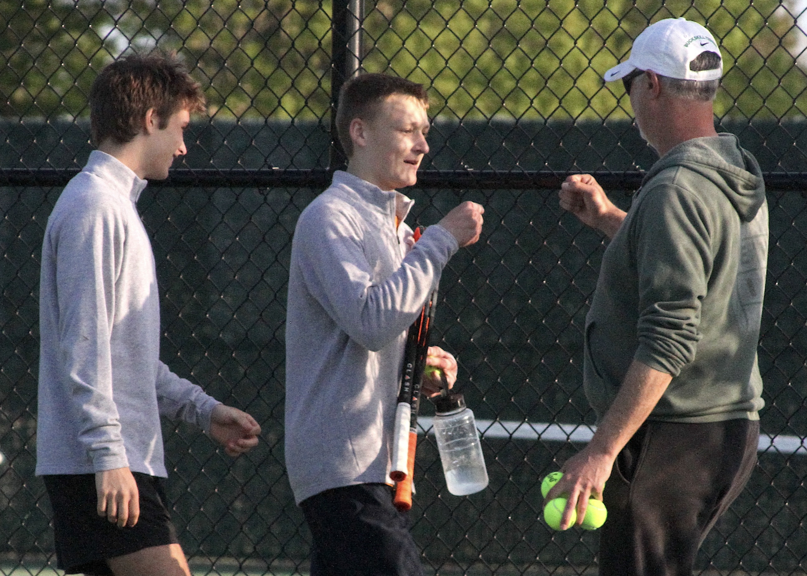 East Hampton sophomore Kiefer Mitchell is congratulated by senior captain Max Astilean and head coach Kevin McConville following his three-set win that clinched the match for the Bonackers. DESIRÉE KEEGAN