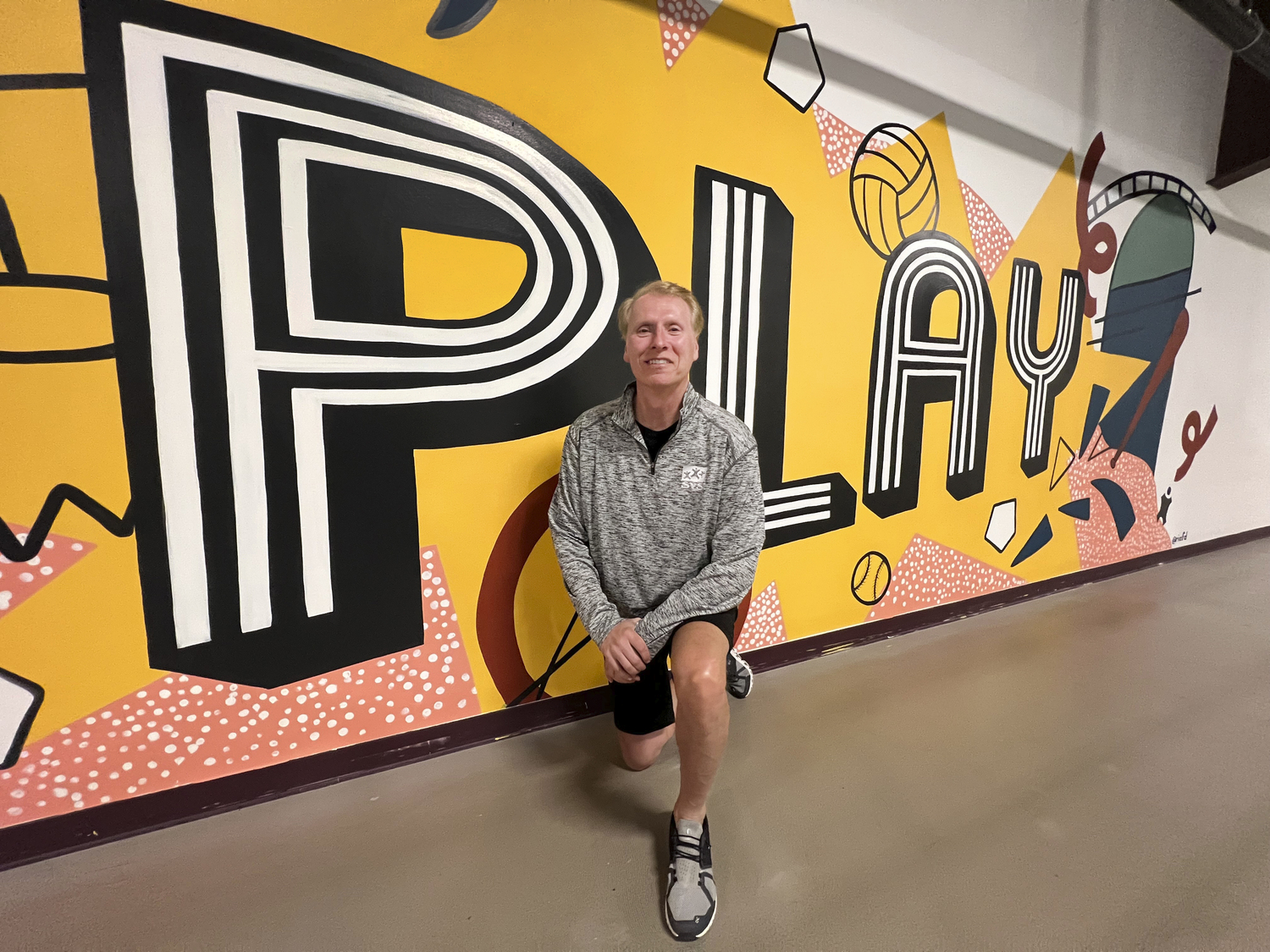 SYS Executive Director Scott Johnson in front of one of the new murals at the facility.  DANA SHAW