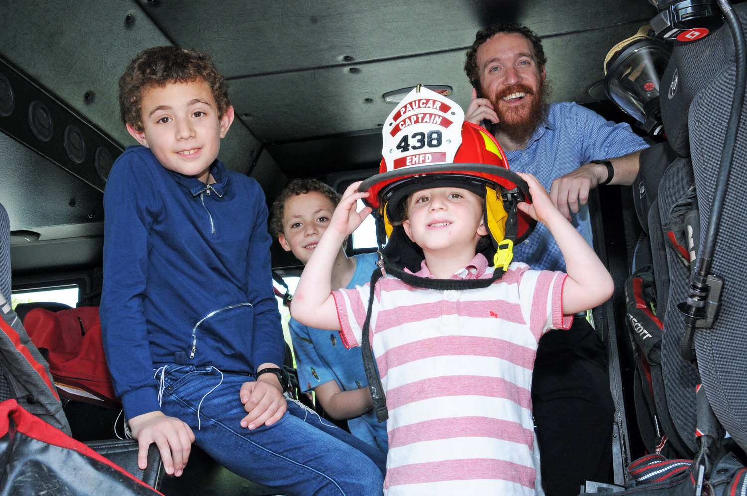 Sholom, Zelig, Shimon and Rabbi Aizik Baumgarten at the Clubhouse in East Hampton on Sunday for day of family fun and fire emergency service education. The East Hampton Fire Department Chiefs not only greeted attendees, but also brought 2 fire trucks for all ages to tour and to see close up what fire apparatus is all about, while enjoying free rounds of Mini Golf, food, drinks and live band music. Proceeds will benefit the future purchase of a locally touring Fire Safety House trailer, a full-featured scaled down home for learning fire prevention methods for every room of the home. RICHARD LEWIN