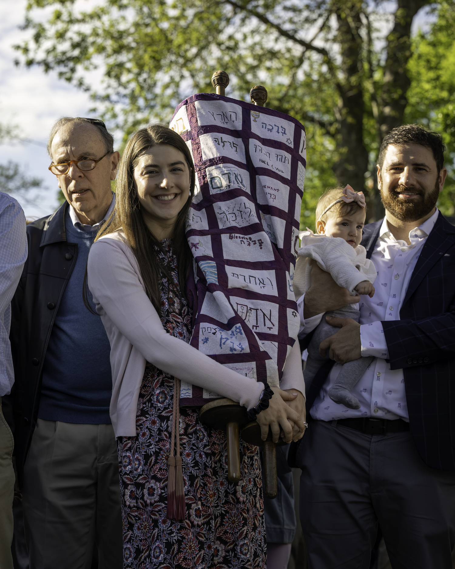 Breanne Sender holds a Torah and her husband, Boris, holds their daughter, Amelia, during Friday's procession. MARIANNE BARNETT