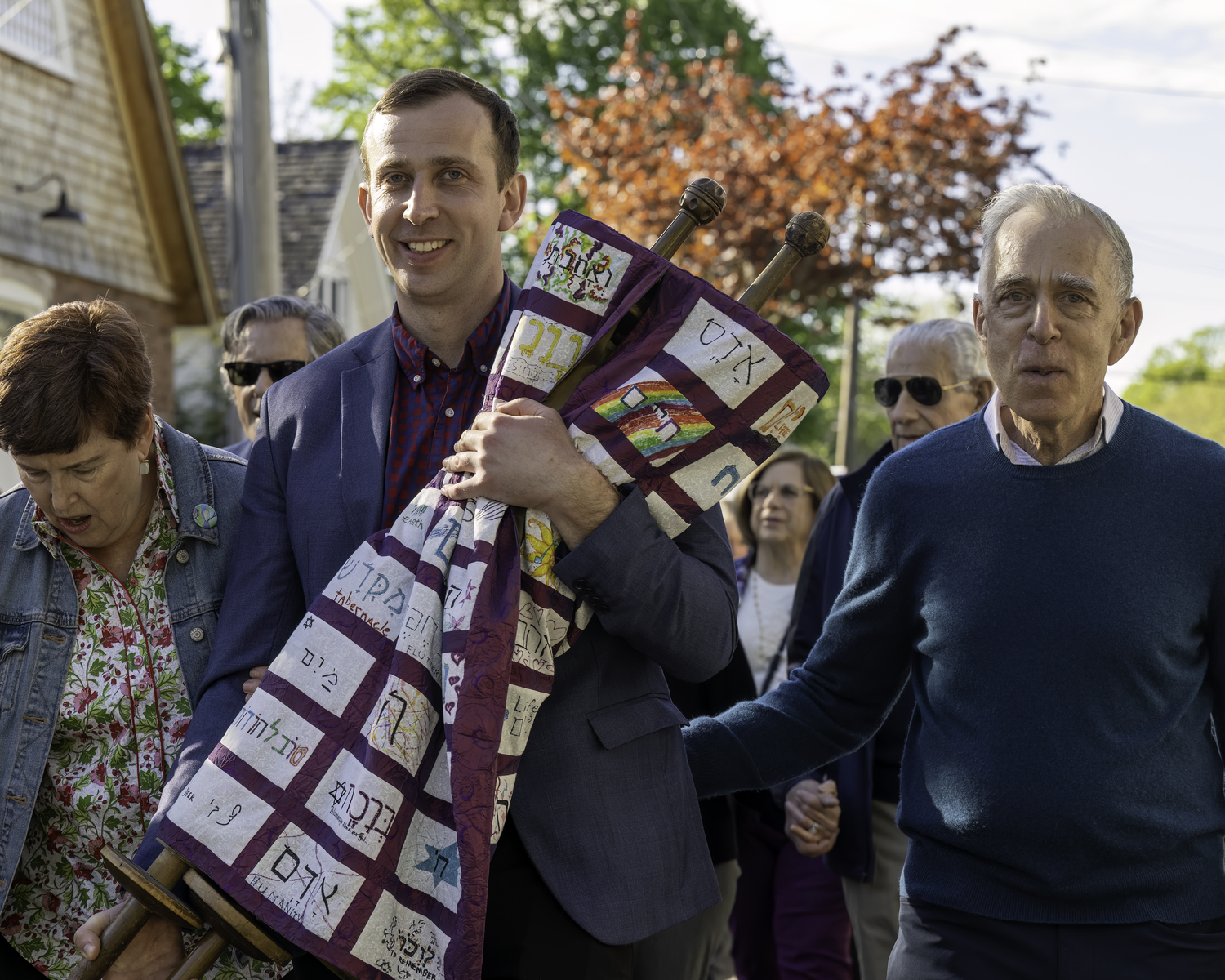 Nathaniel Oppenheimer, carrying a Torah, is accompanied by his mother, Leah Oppenheimer, and father, Dr. John Oppenheimer. MARIANNE BARNETT