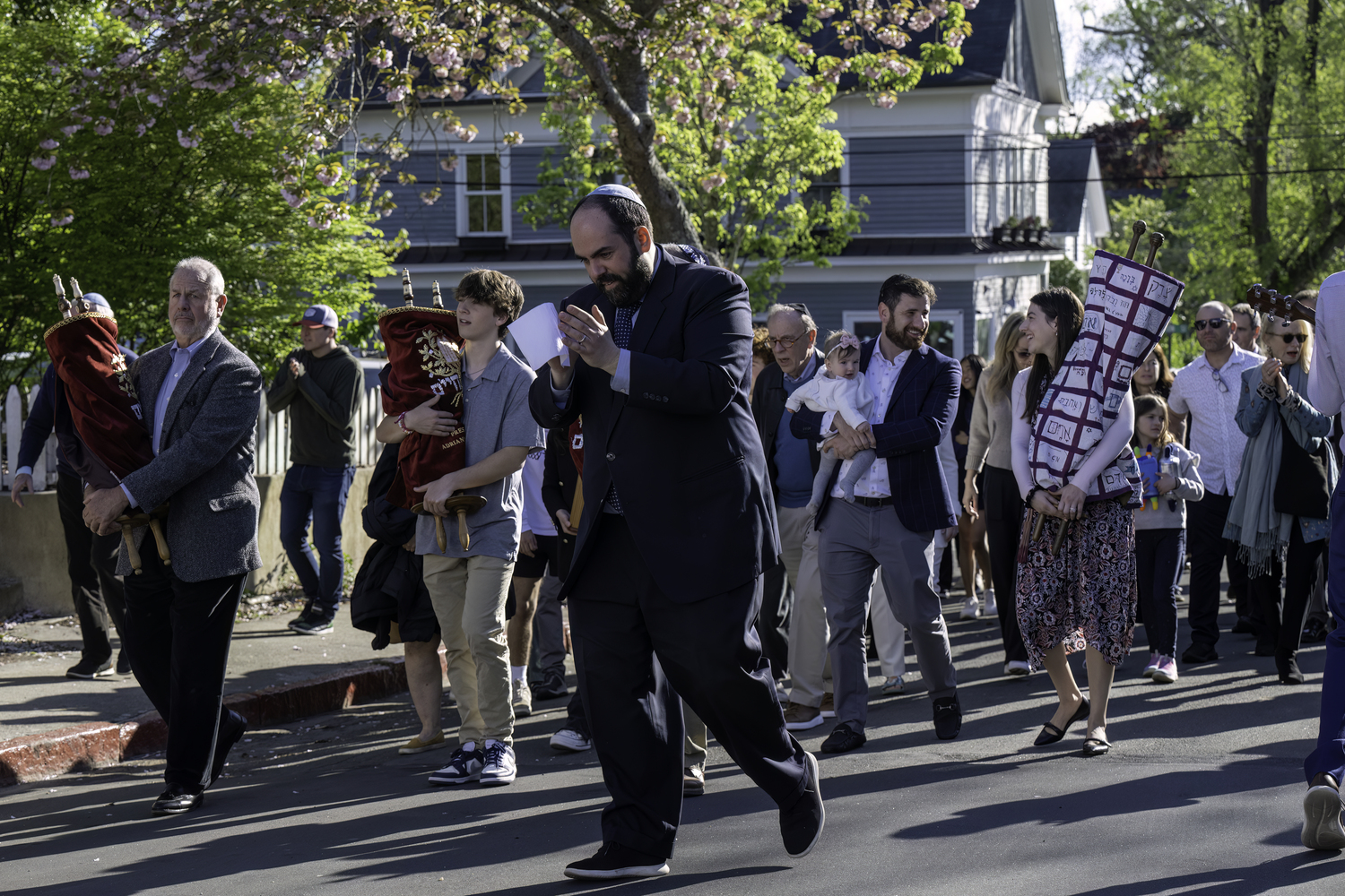 Rabbi Daniel Geffen leads the congregation of Temple Adas Israel in a procession back to its Atlantic Avenue synagogue on Friday. MARIANNE BARNETT