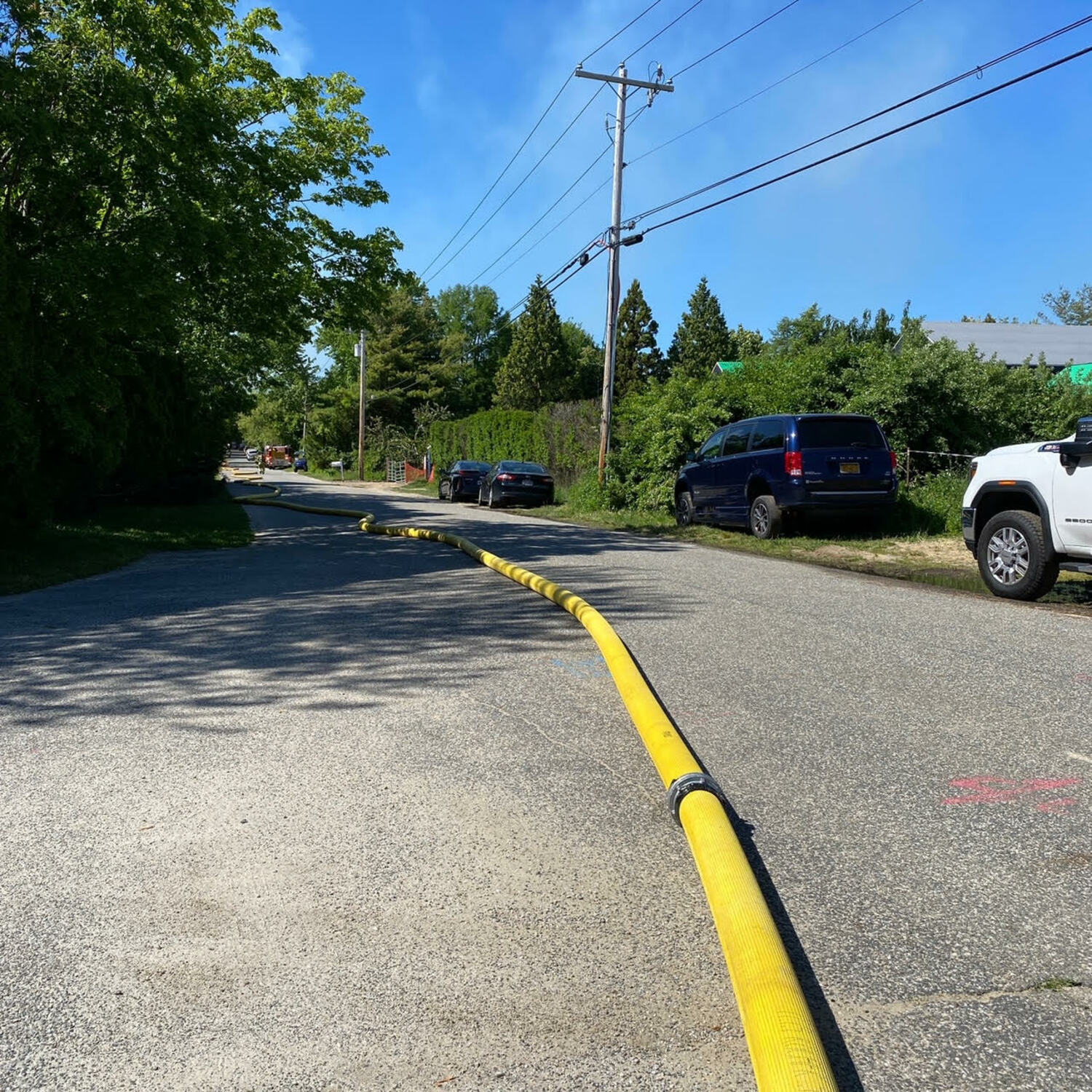 Fire hose stretched for yards down Farmstead Lane as responders battled the blaze in Water Mill on Sunday.