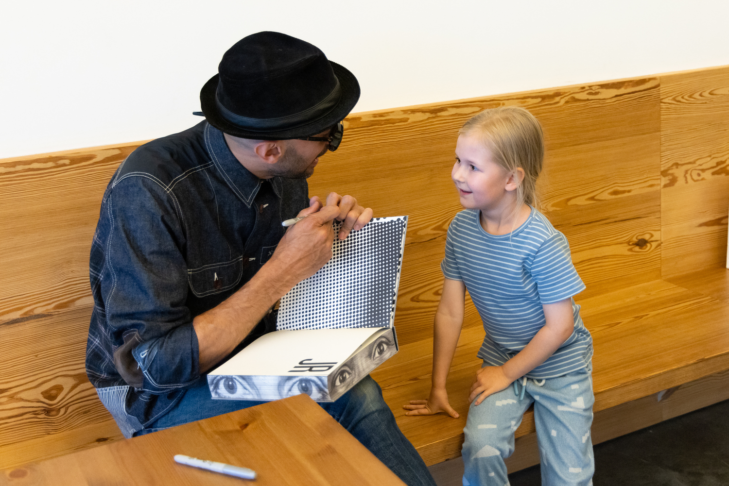 Artist JR meets with a young fan of his work at the Parrish Art Museum on June 9. JENNY GORMAN