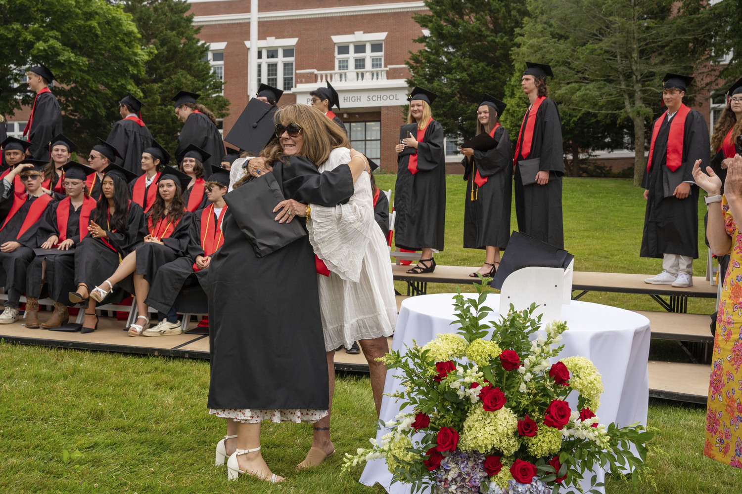 Pierson School Board President Sandi Kruel hugs her niece Ashley Weatherwax at commencement on Saturday evening.    RON ESPOSITO