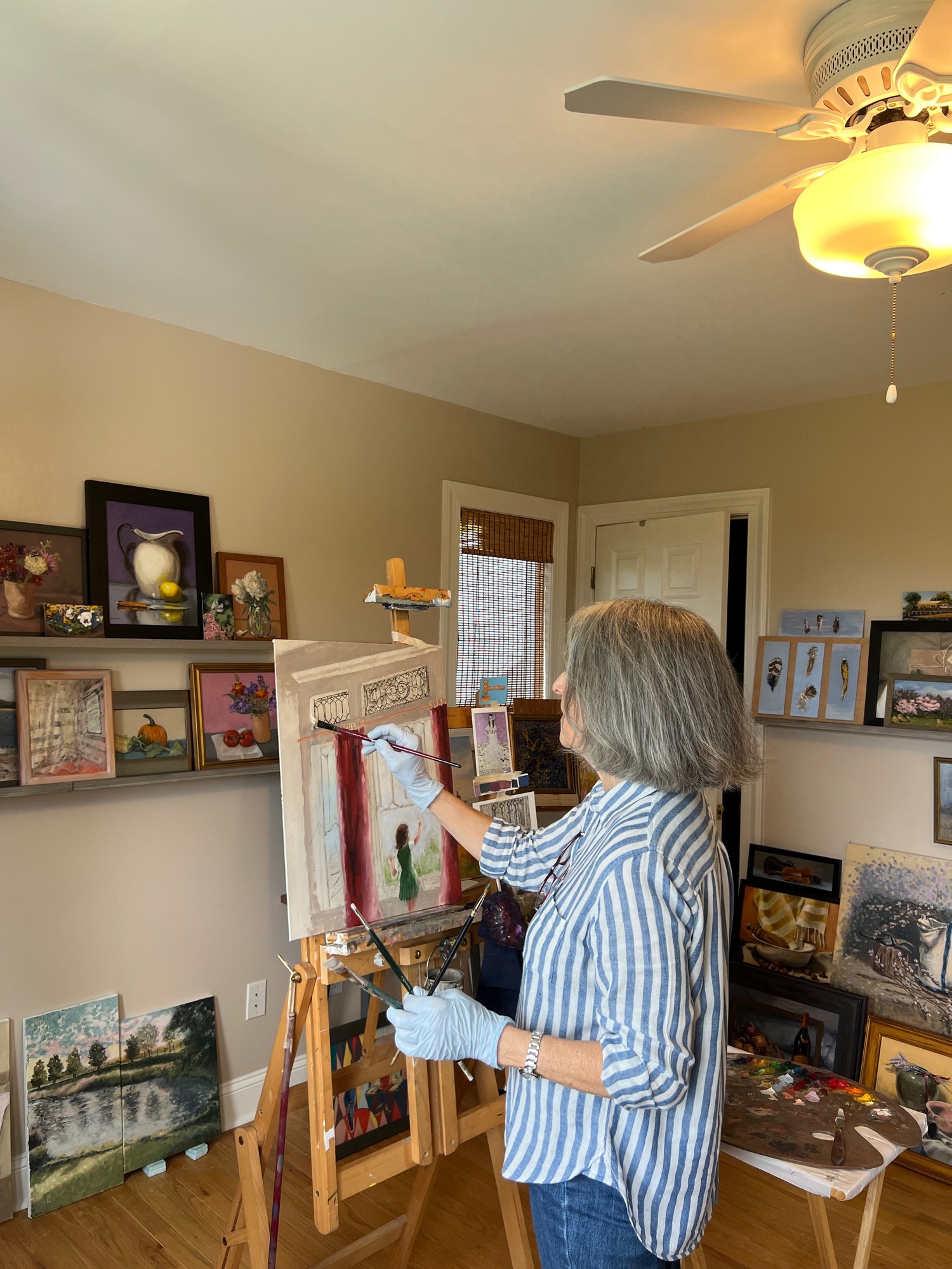 Ann Lombardo painting in her home studio. The piece on the easel will be in her 